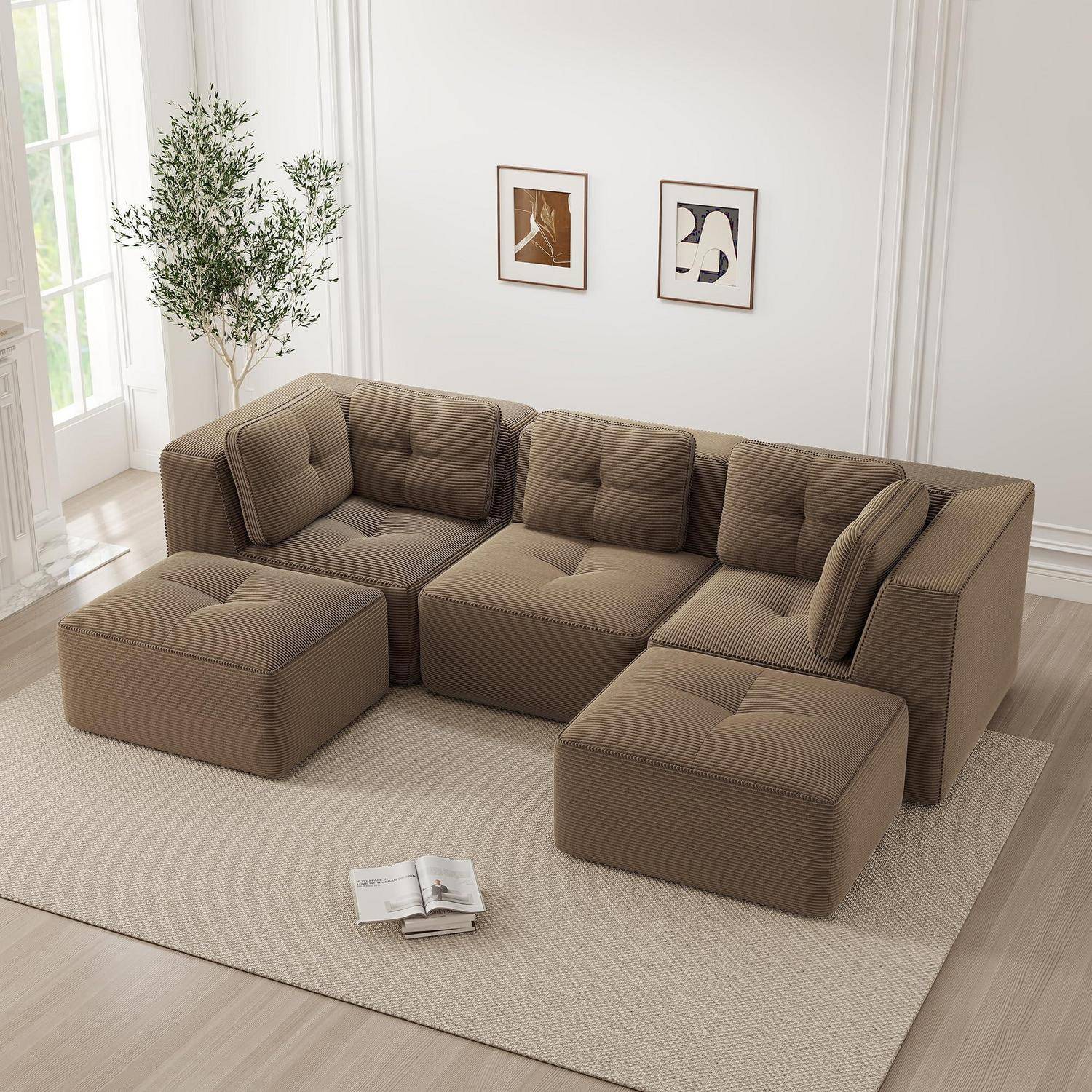 Braunes modulares Ecksofa mit zwei Ottomanen und einem Teppich in einem hellen, minimalistischen Wohnzimmer; kleine Pflanze, gerahmte Wandkunst und aufgeschlagenes Buch in der Nähe.