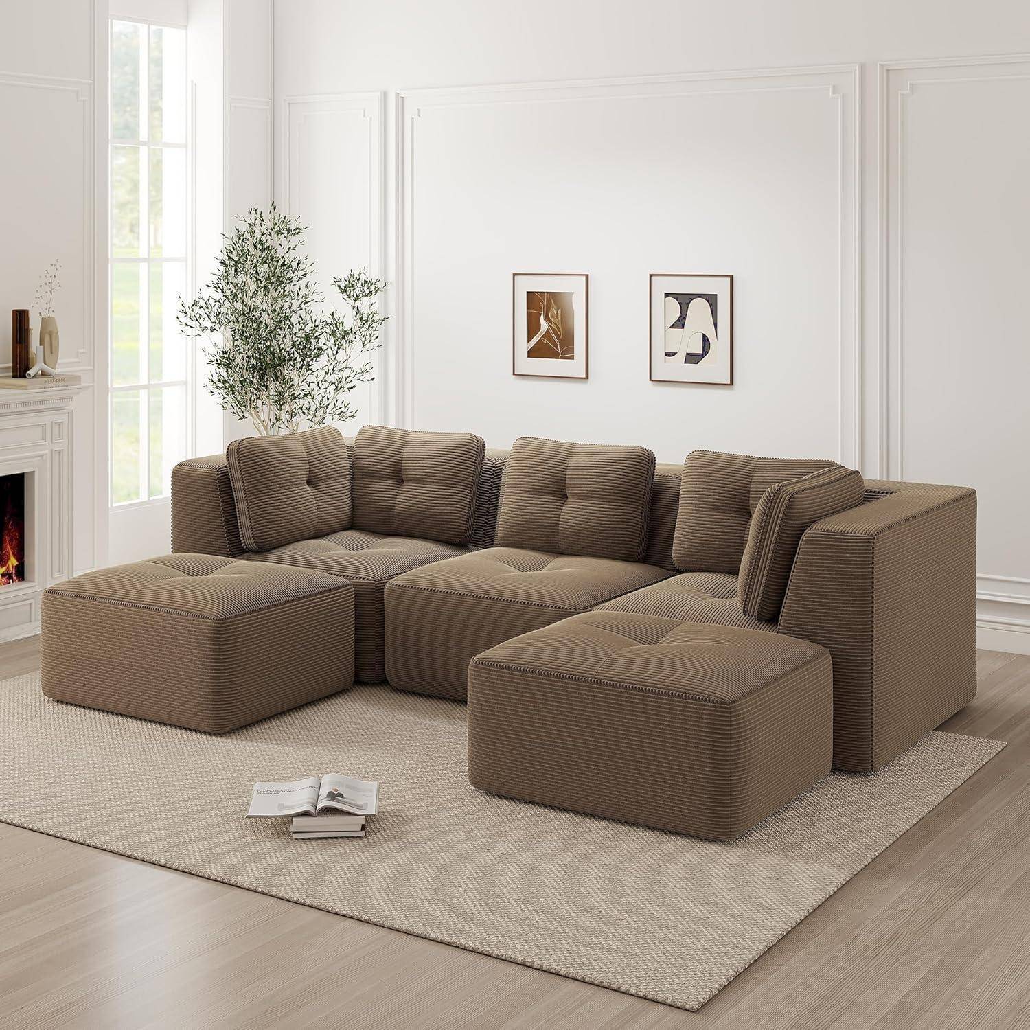 Braunes modulares Ecksofa mit zwei Ottomanen in einem hellen minimalistischen Wohnzimmer mit Wandkunst, Pflanze und Kamin.