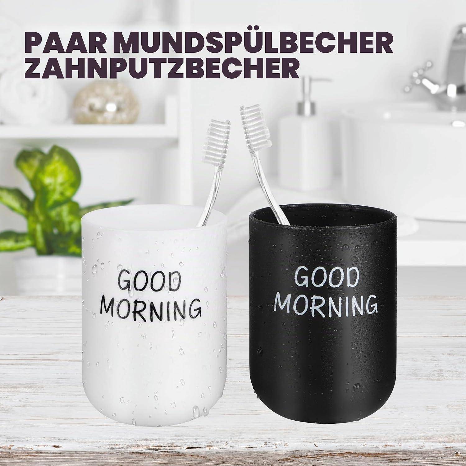 Zwei Zahnputzbecher, einer weiß und einer schwarz, jeweils mit der Aufschrift „GUTEN MORGEN