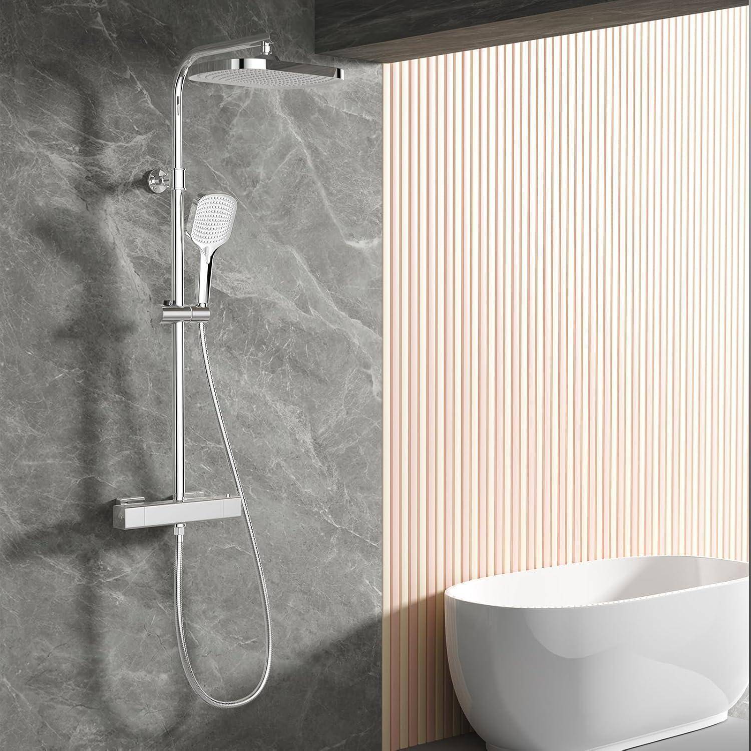 Modernes Badezimmer mit verchromter Regendusche an einer graunen Steinwand neben einer freistehenden weißen Badewanne und einer gestreiften Akzentwand.