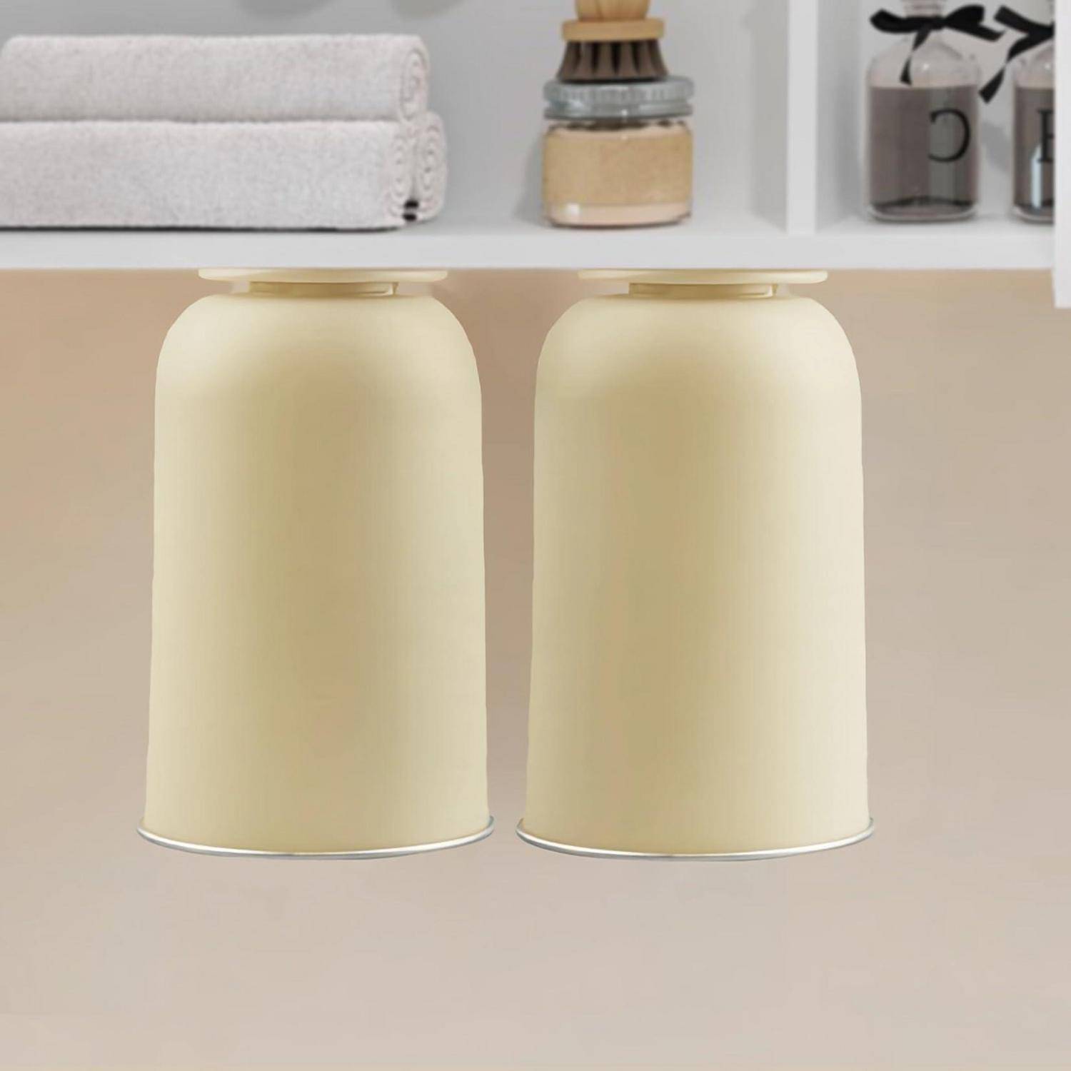 Zwei cremefarbene zylindrische Pendelleuchten hängen nebeneinander unter einem Regal in einem minimalistischen Interieur.