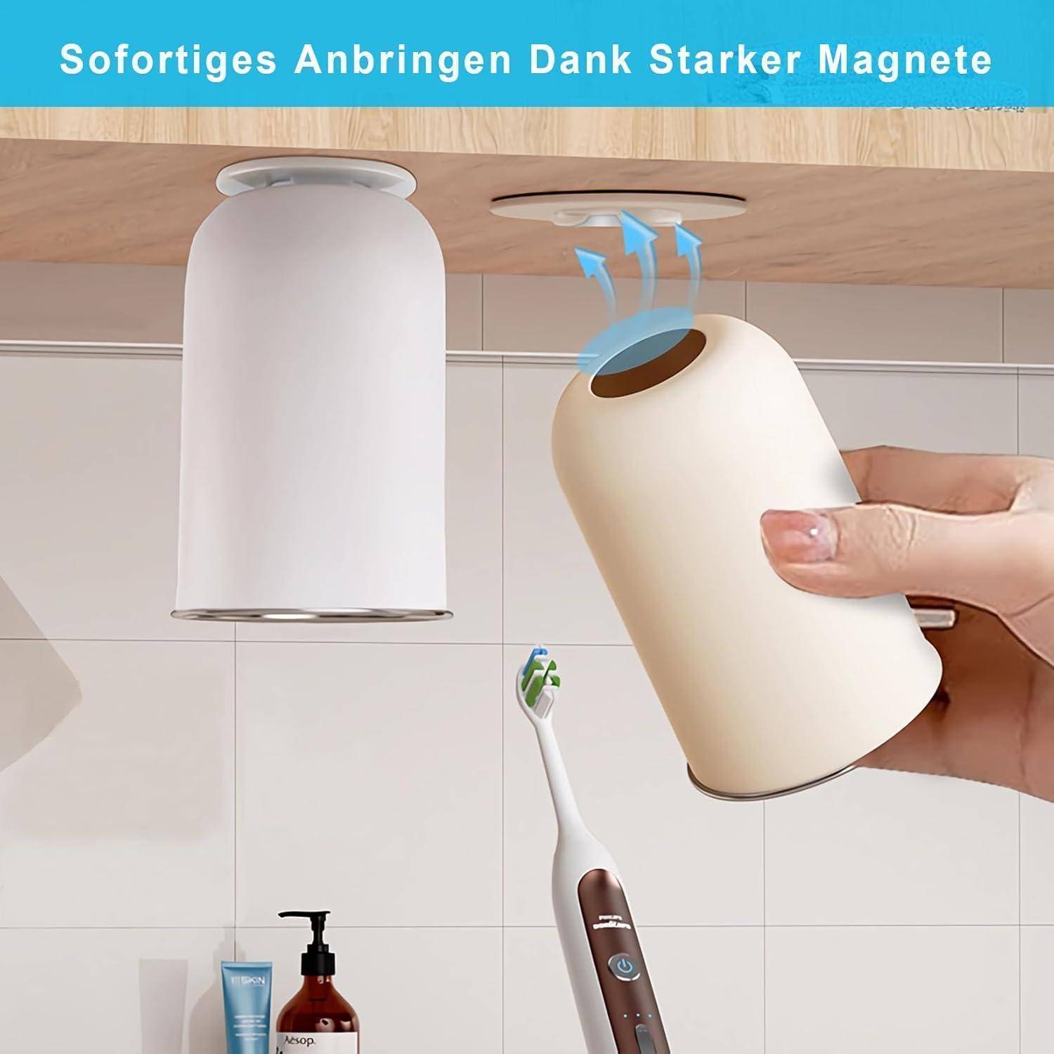 Tragbarer Magnetbecher-Halter wird unter einen Holzschrank angebracht, wobei ein passender Halter bereits in der Nähe montiert ist; deutscher Text sagt „Sanftes Anbringen Dank Starker Magnete