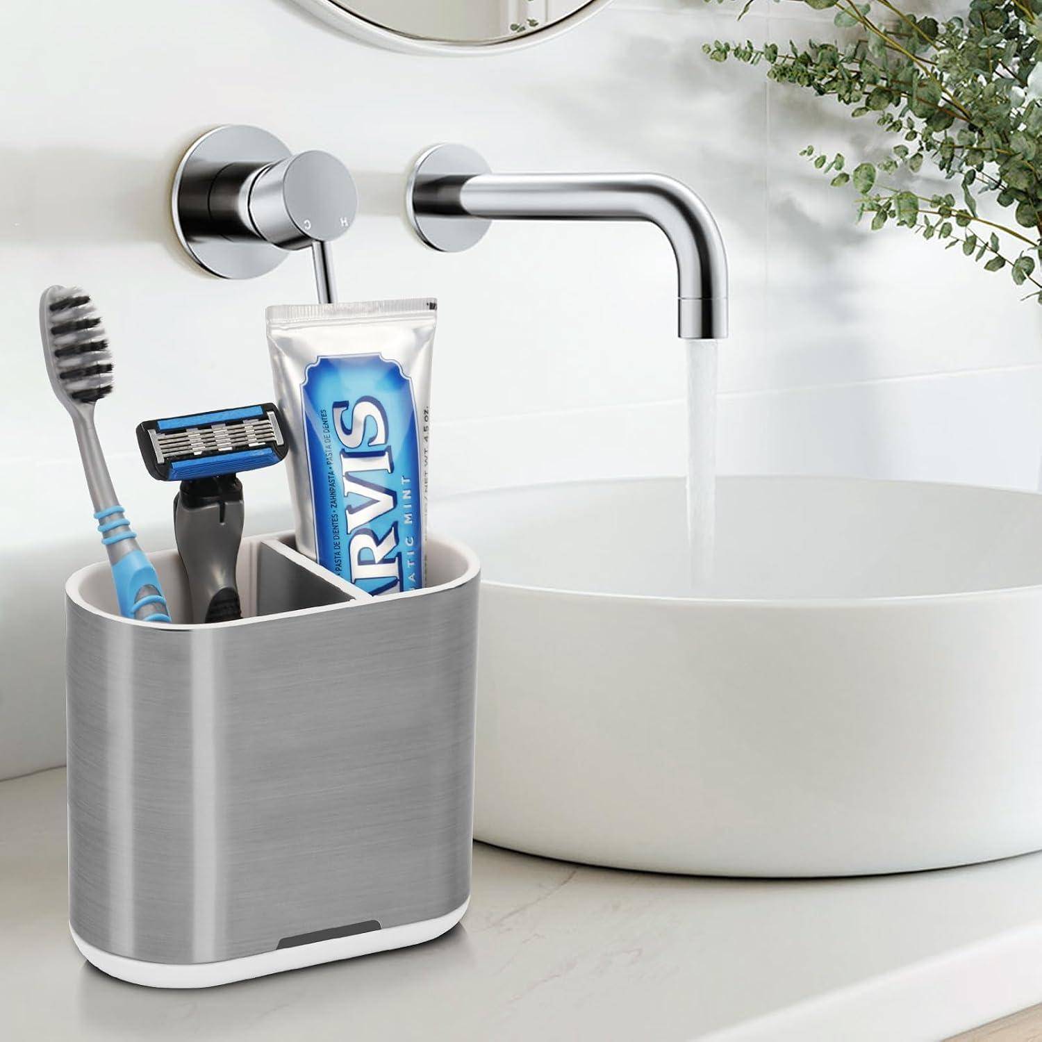 Badezimmerspüle mit laufendem Wasserhahn und einem Ablagebehälter auf der Arbeitsplatte, der eine Zahnbürste, einen Rasierer und eine Zahnpastatube enthält.