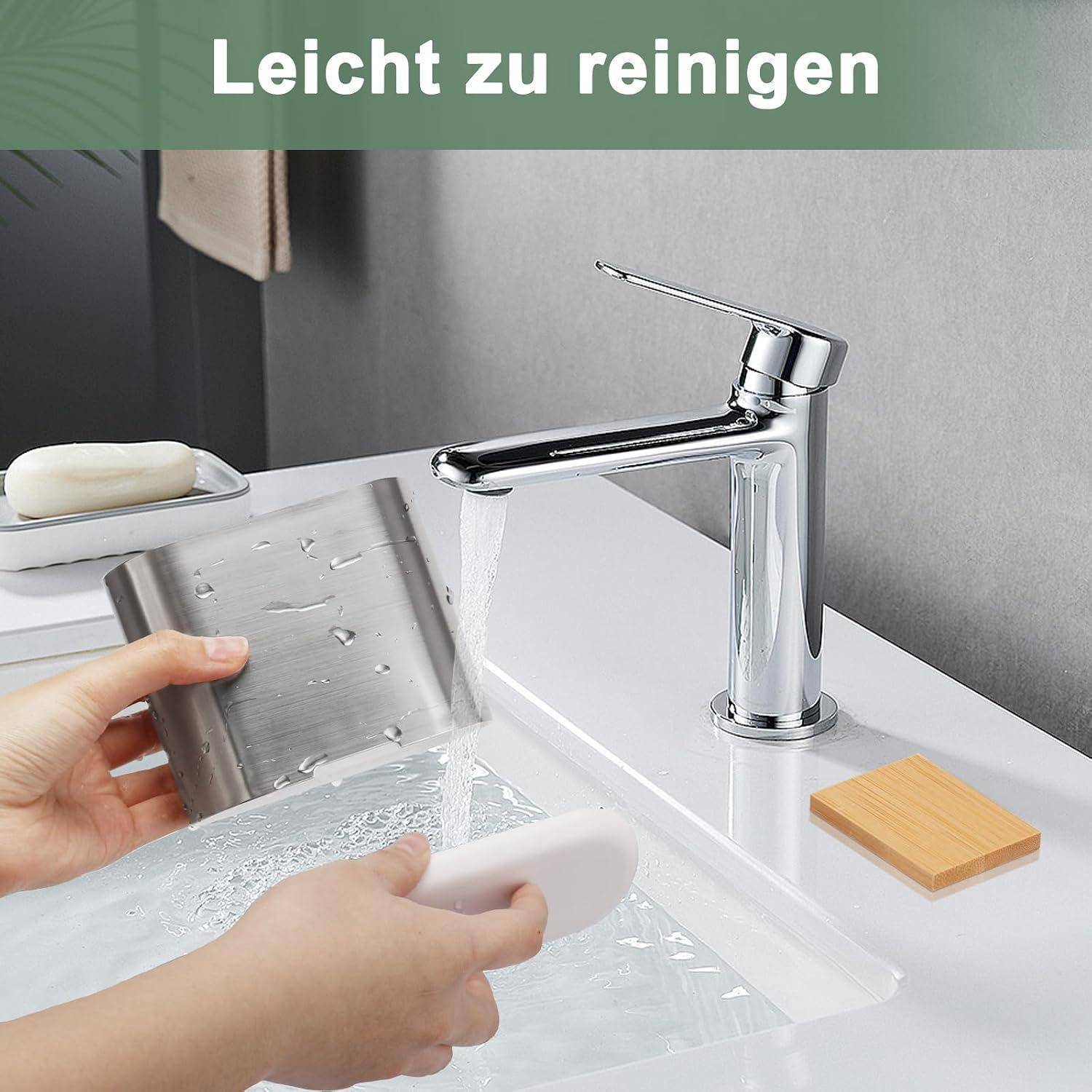 Chromwasserhahn im Badezimmer mit fließendem Wasser, während Hände ein Metallgitter unter dem Wasserhahn abspülen; deutscher Text oben sagt „Leicht zu reinigen