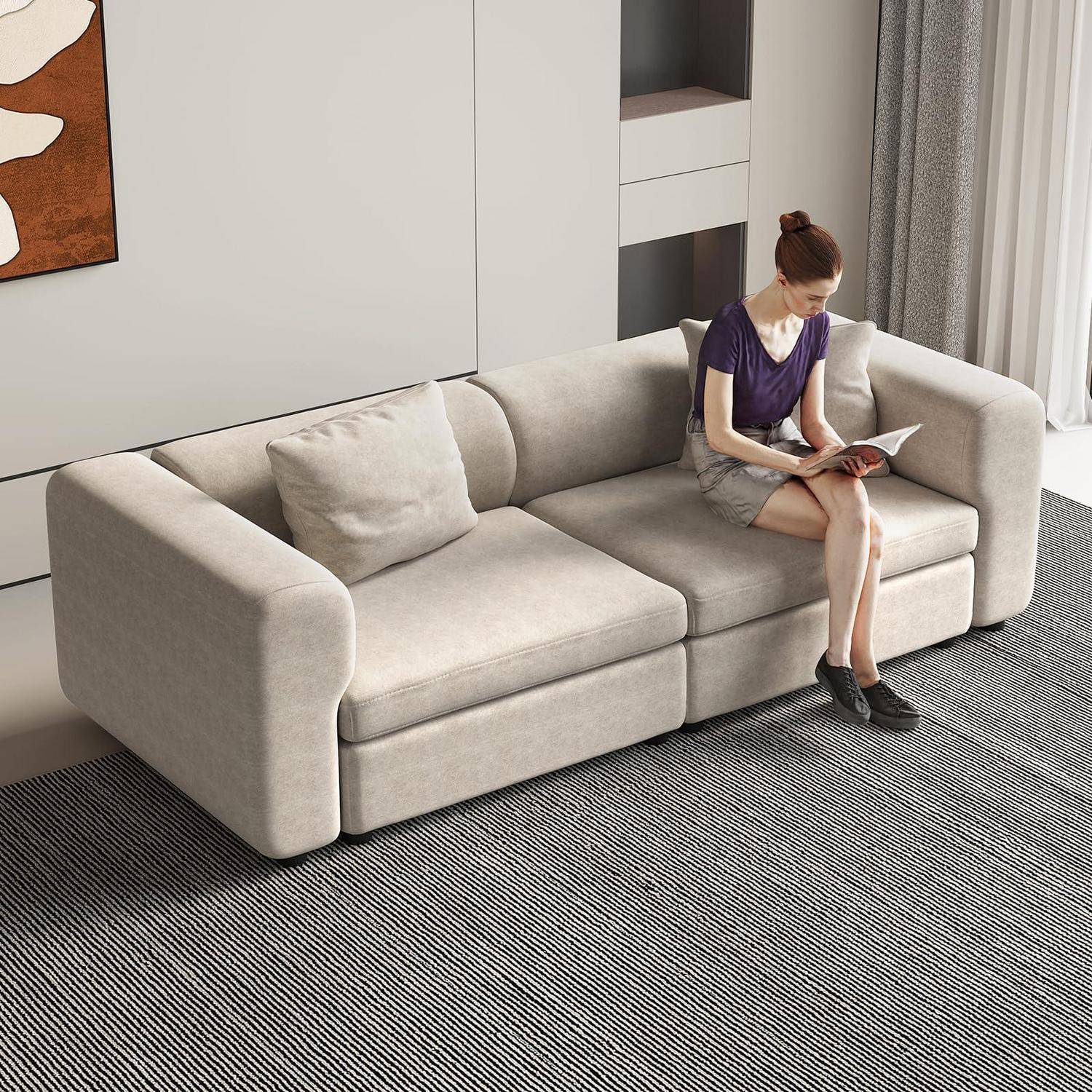 Frau, die auf einem hellbeigen Ecksofa in einem modernen Wohnzimmer liest.