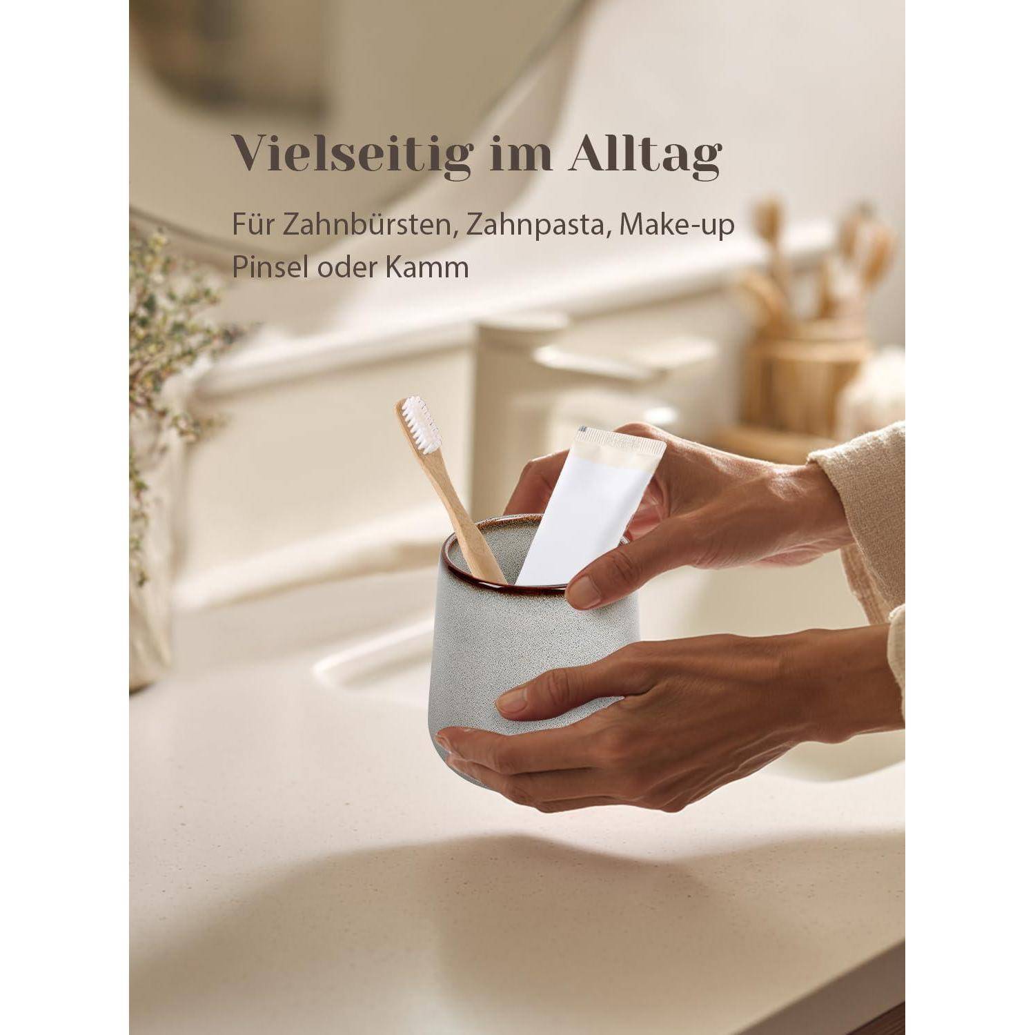 Hand hält einen kleinen Becher-Organizer neben einem Badezimmerspüle, mit Zahnbürste, Zahnpasta, Makeup-Pinsel und Kamm; deutscher Text sagt „Vielseitig im Alltag