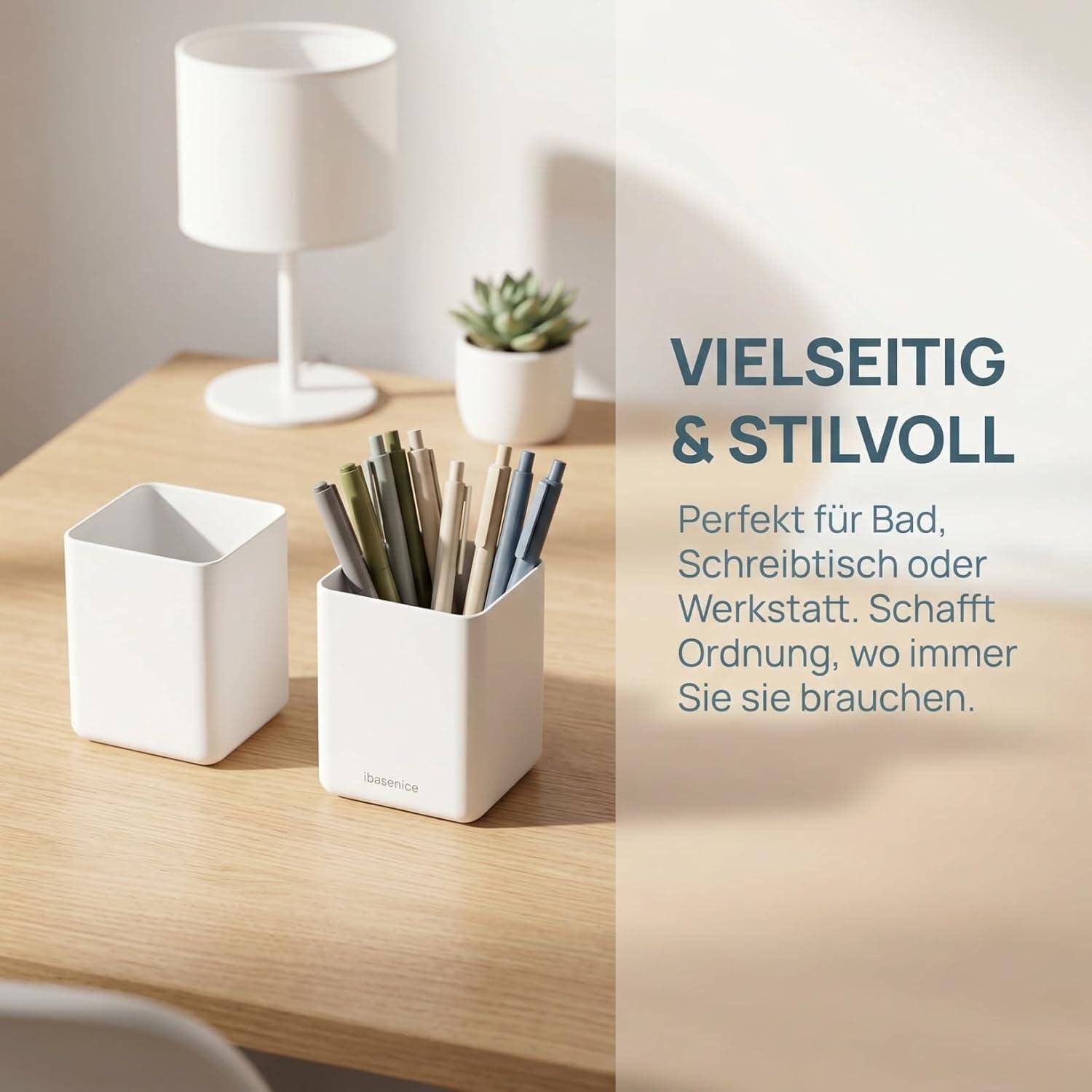 Zwei weiße Schreibtischorganizer auf einem Holztisch neben einer Lampe und einer Pflanze, mit deutschem Text, auf dem „VIELSEITIG & STILVOLL