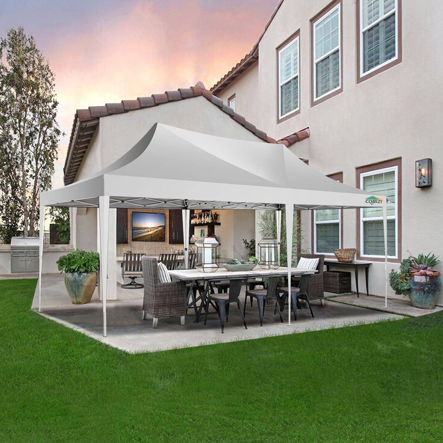Hinterhofterrasse mit einem weißen Pavillonzelt über einem Gartenesstisch und Stühlen neben einem Haus, umgeben von grünem Rasen.