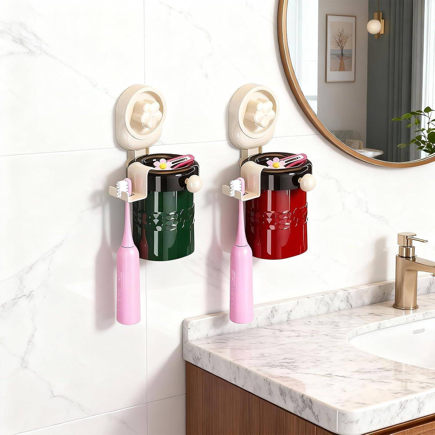 Zwei an der Wand montierte Zahnbürstenhalter mit Saugnapfen, jeder mit einer rosa Zahnbürste, einer grünen und einer roten, neben einem Badezimmerspüle und Spiegel.
