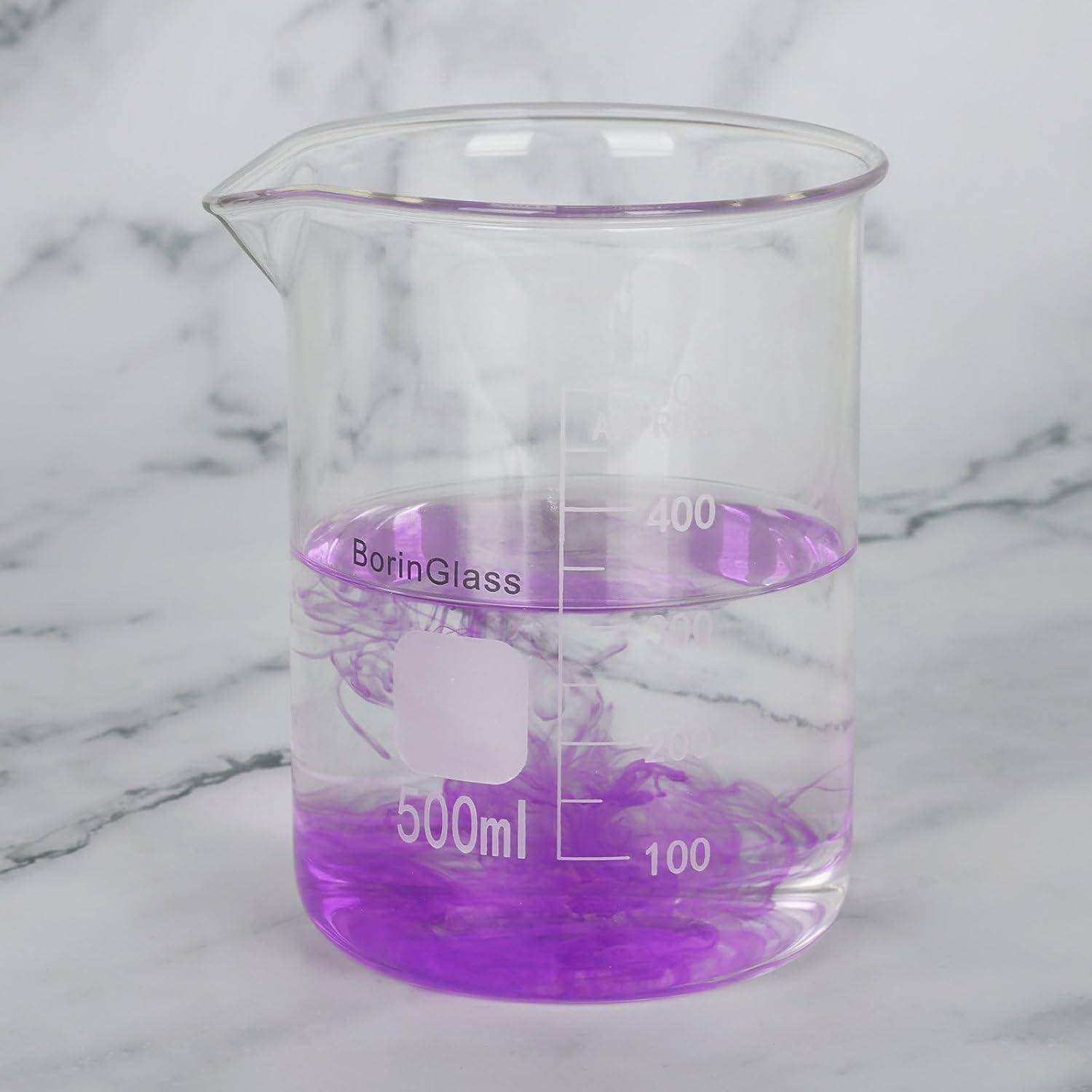 Ein klares Becherglas mit 500 ml Inhalt mit violetten Flüssigkeitswirbeln auf einer MarmorOberfläche.