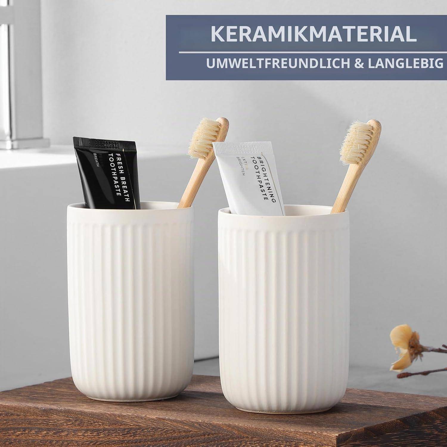 Zwei weiße Keramik-Badezimmertassen halten Zahnbürsten und Zahnpastatuben auf einer Holzoberfläche; Banner lautet „KERAMIKMATERIAL UMWELTFREUNDLICH & LANGLEBIG