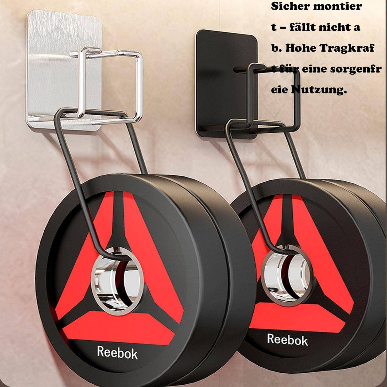 Zwei Reebok-Bauchtrainer an Wandhaken montiert, dargestellt als sichere, platzsparende Lagerung mit deutschem Text über sichere Montage und hohe Tragfähigkeit.
