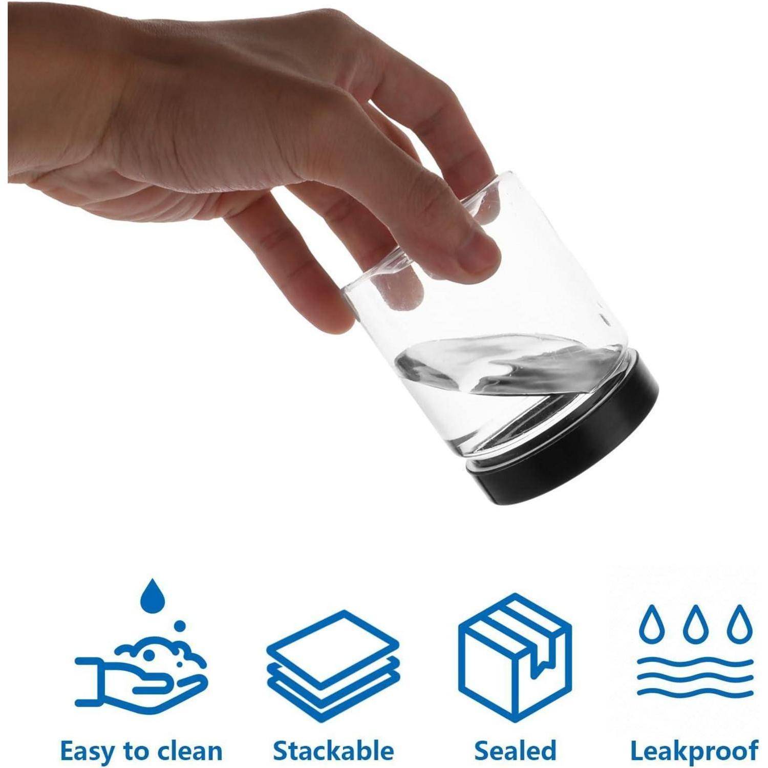 Hand, die ein kleines geneigtes Glasgefäß mit schwarzem Deckel über Symbolen hält, die mit „Leicht zu reinigen", „Stapelbar"", „Versiegelt"" und „Auslaufsicher"" beschriftet sind.