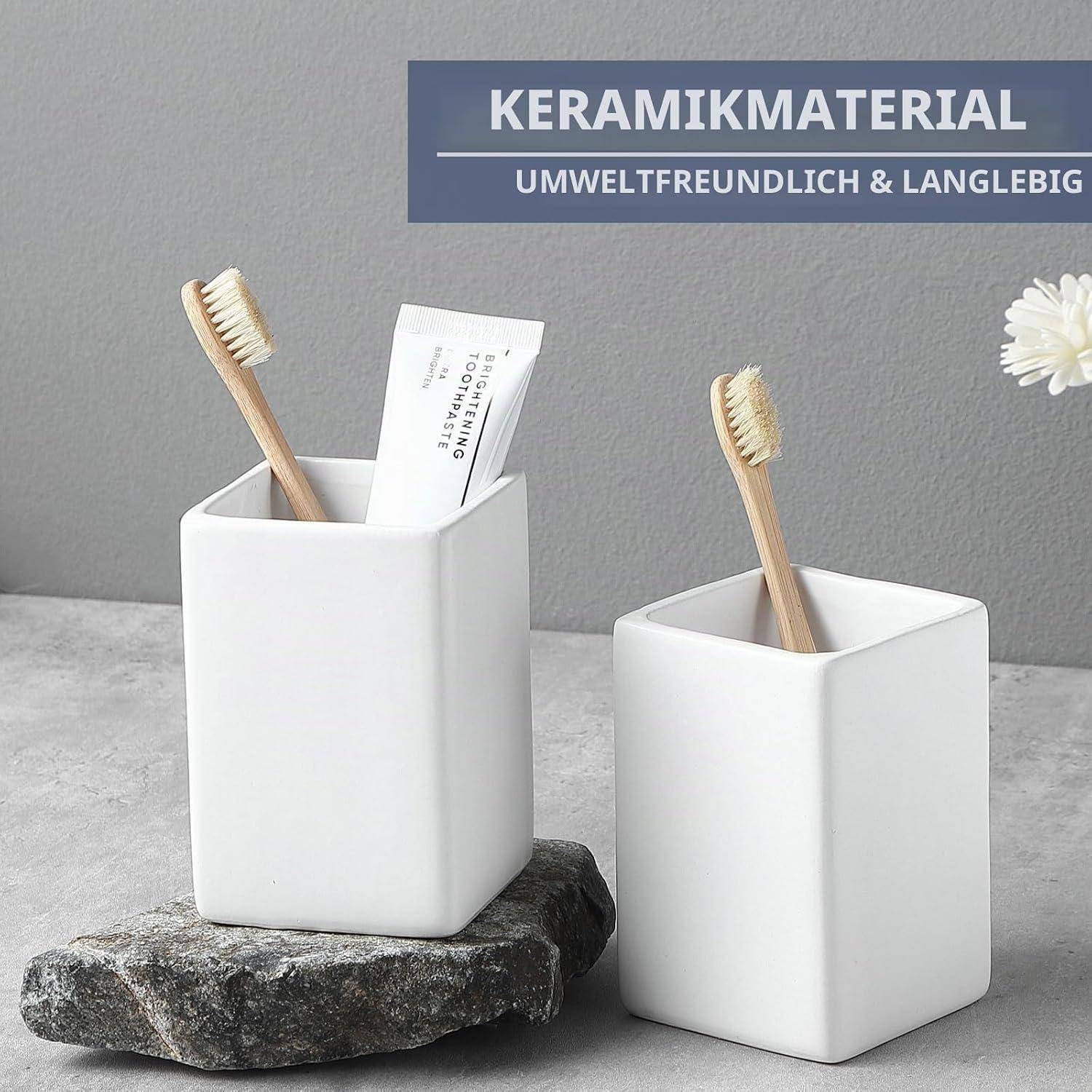 Zwei weiße Keramik-Zahnbürstenhalter mit Bambus-Zahnbürsten und Zahnpasta auf einer Steinoberfläche; Banner liest „KERAMIKMATERIAL