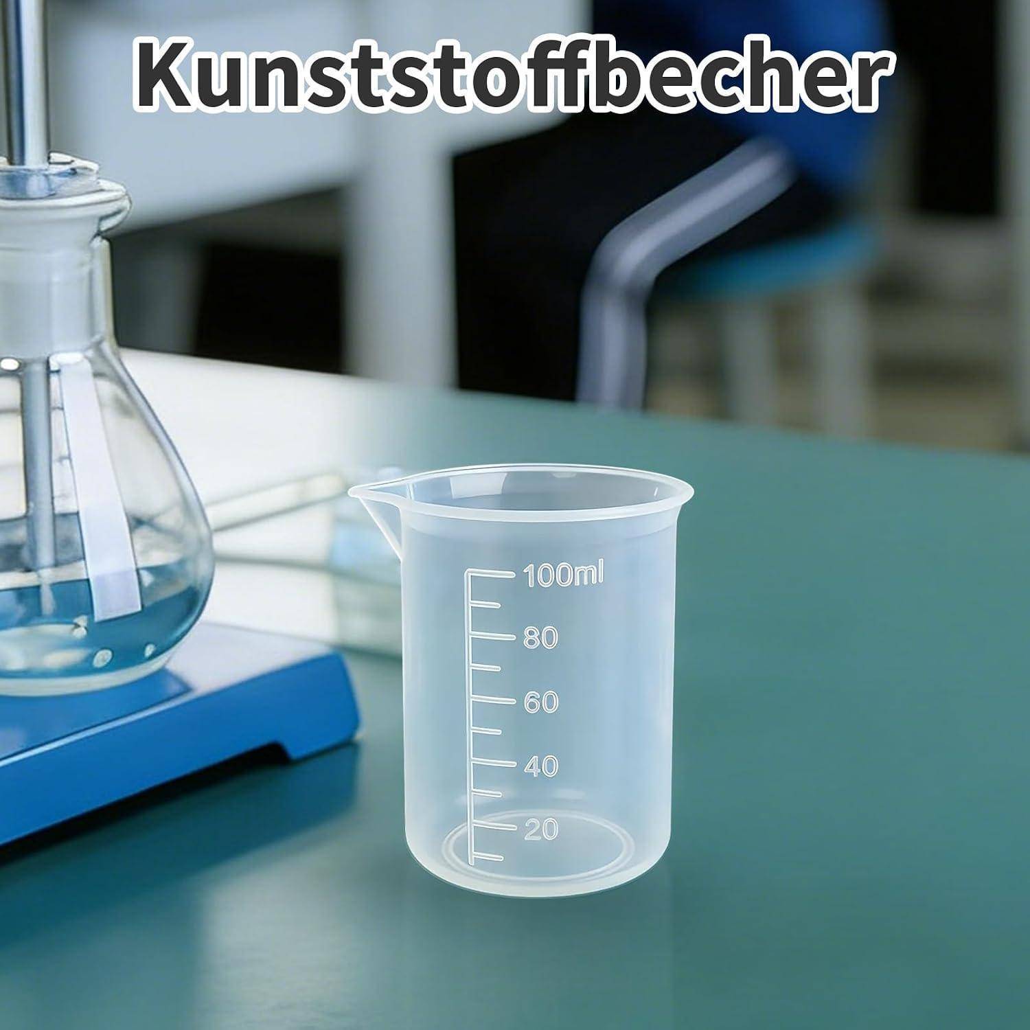 Klarer Kunststoffbecher auf einer Laborbank mit der Beschriftung 'Kunststoffbecher', markiert in Millilitern bis 100 ml.