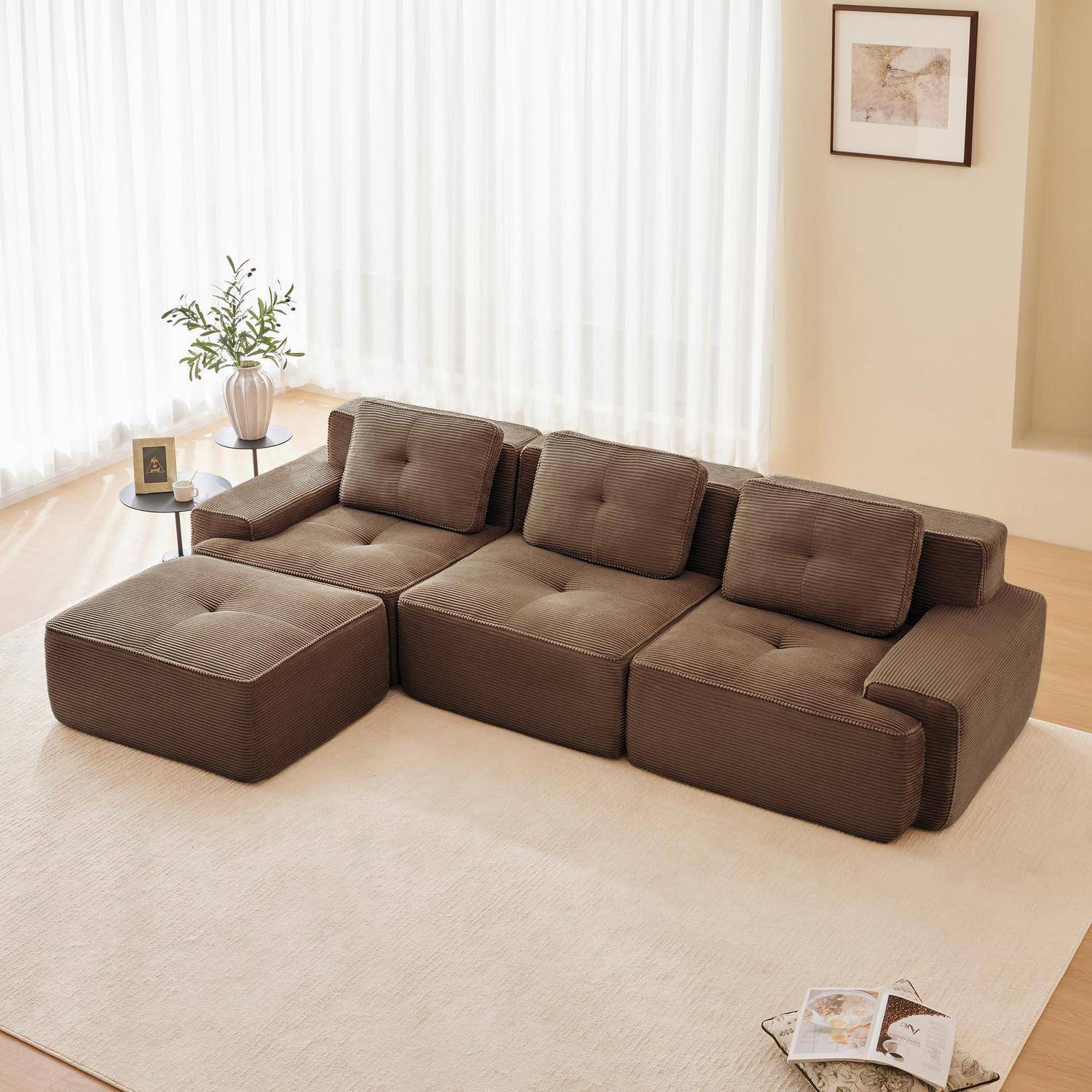 Braunes modulares Ecksofa mit Chaiselongue in einem hellen, minimalistischen Wohnzimmer, neben einem kleinen Beistelltisch und einer Pflanze, mit einem cremefarbenen Teppich und Wandkunst.