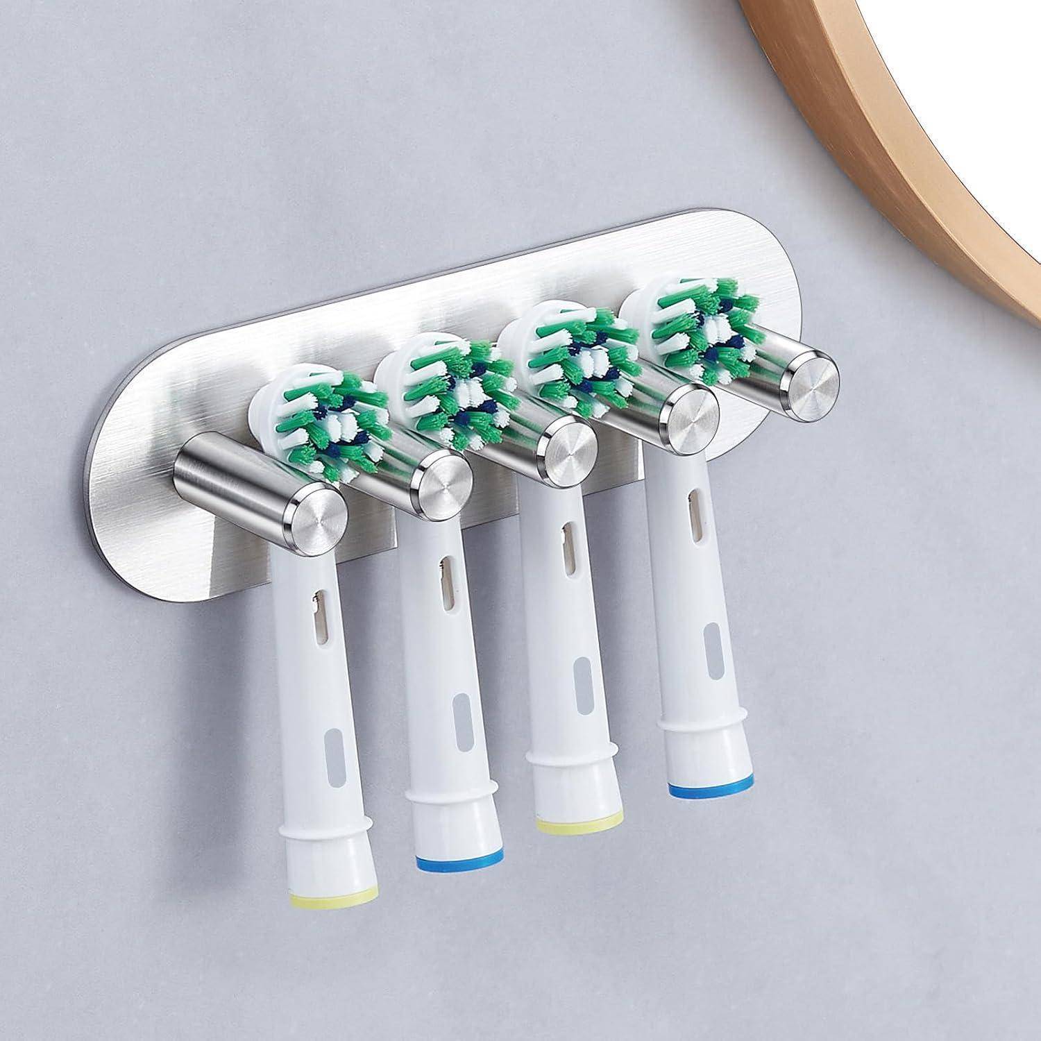 Wandmontierter Zahnbürstenhalter mit vier elektrischen Zahnbürsten, die an Edelstahlclips hängen.