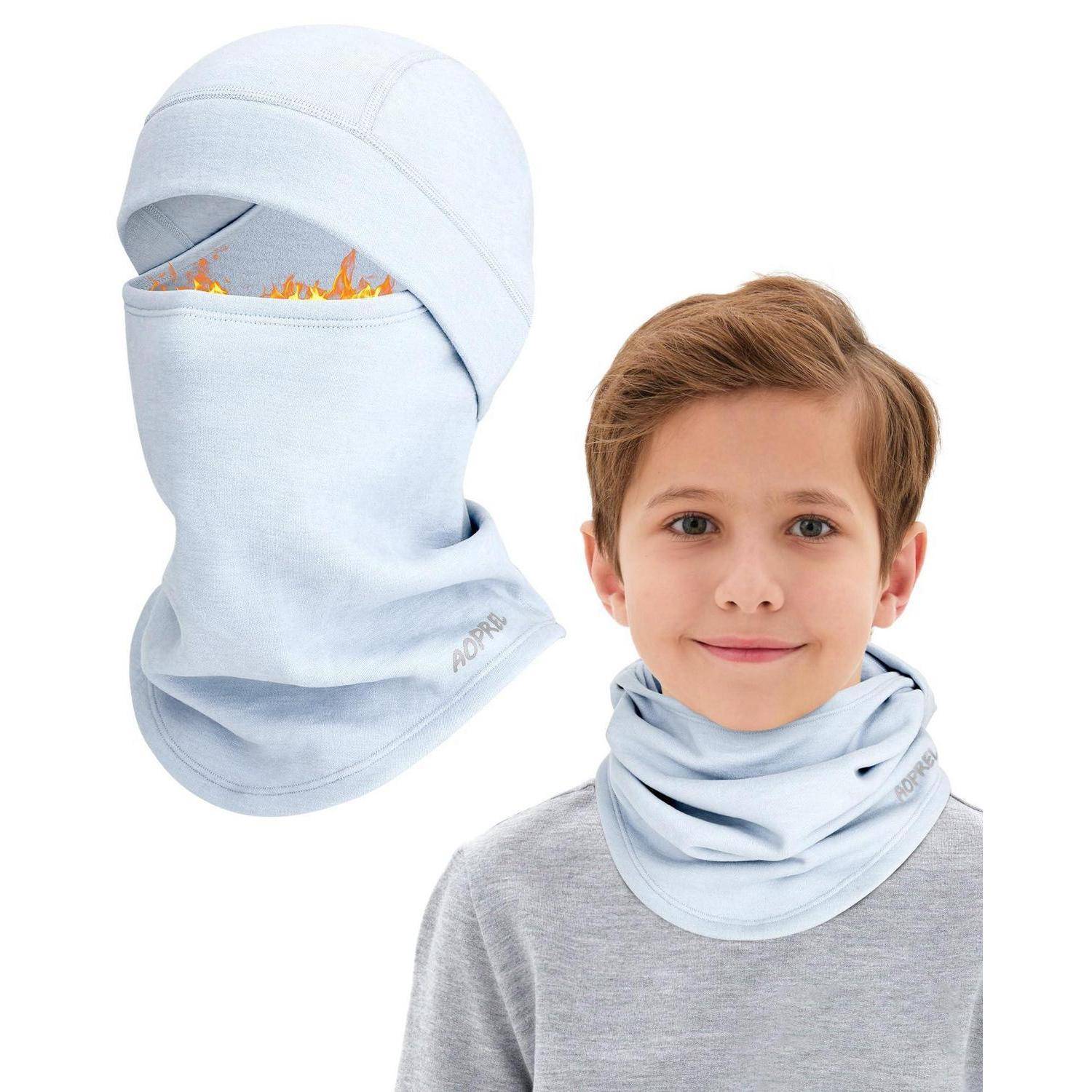 Junge, der eine hellblaue flammenbeständige Kapuze und ein Halstuch trägt; die Vergrößerung zeigt die Kapuze, die das Gesicht bedeckt, mit sichtbaren Flammen im Inneren.