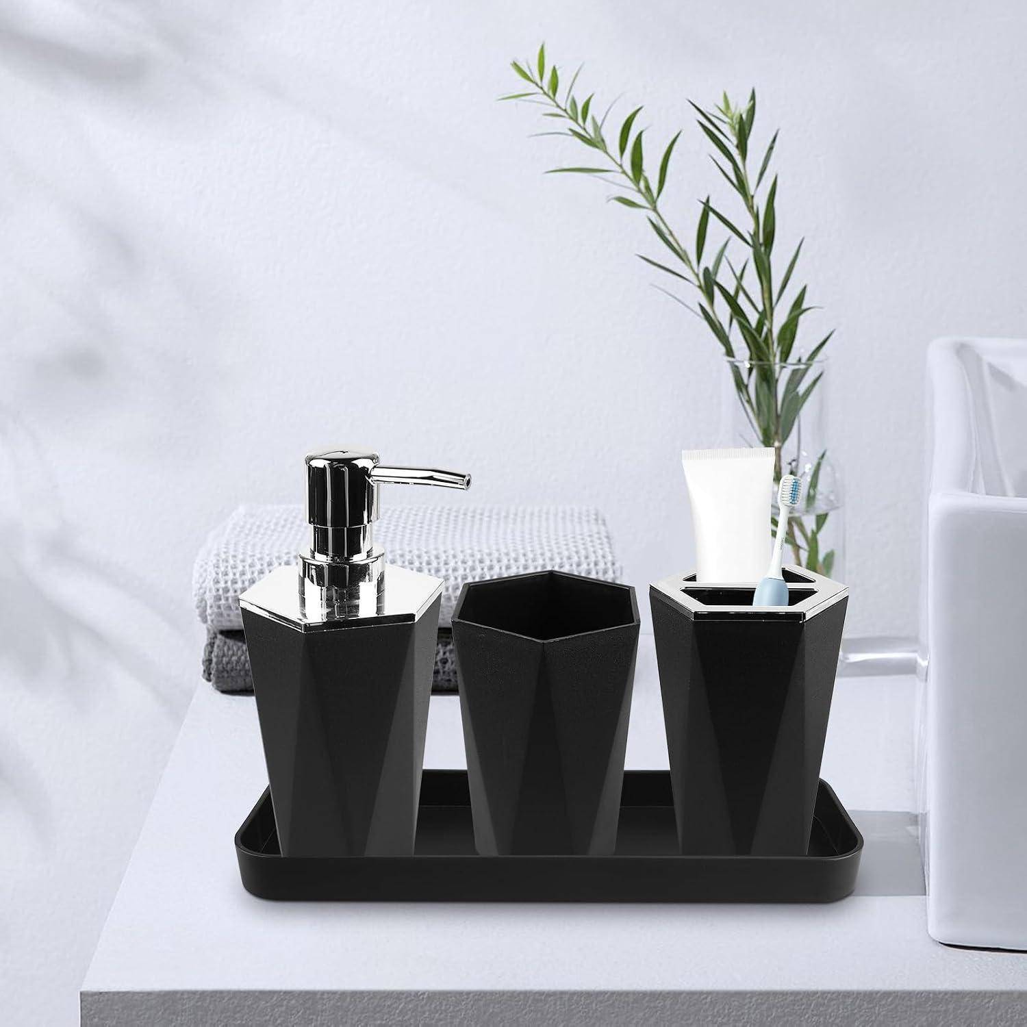 Modernes Badezimmer-Tablett mit schwarzem Seifenspender, Zahnbürstenhalter und Vase mit Grünpflanzen auf einer weißen Oberfläche.