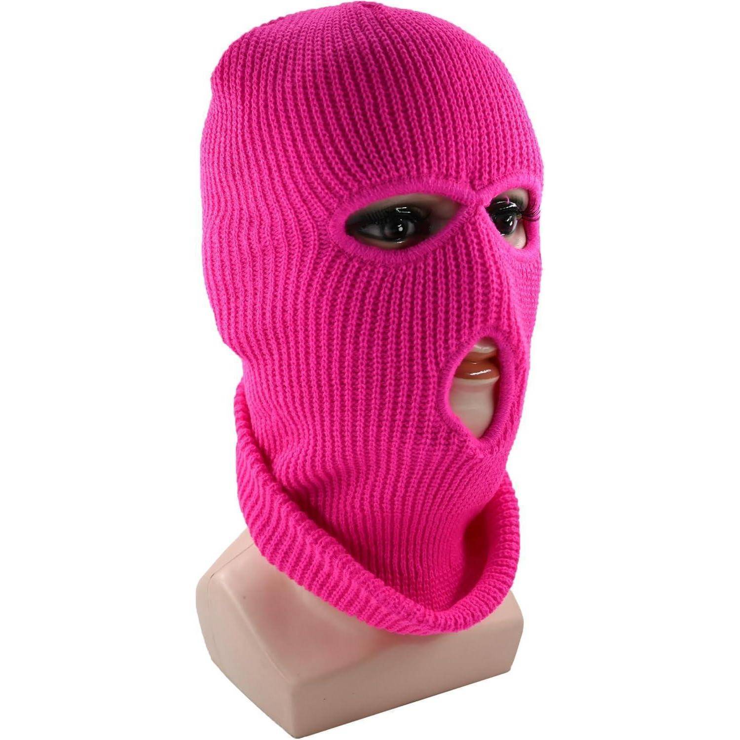 Schaufensterpuppenkopf, der eine leuchtend rosa gestrickte Sturmhaube mit Öffnungen für Augen und Mund trägt.
