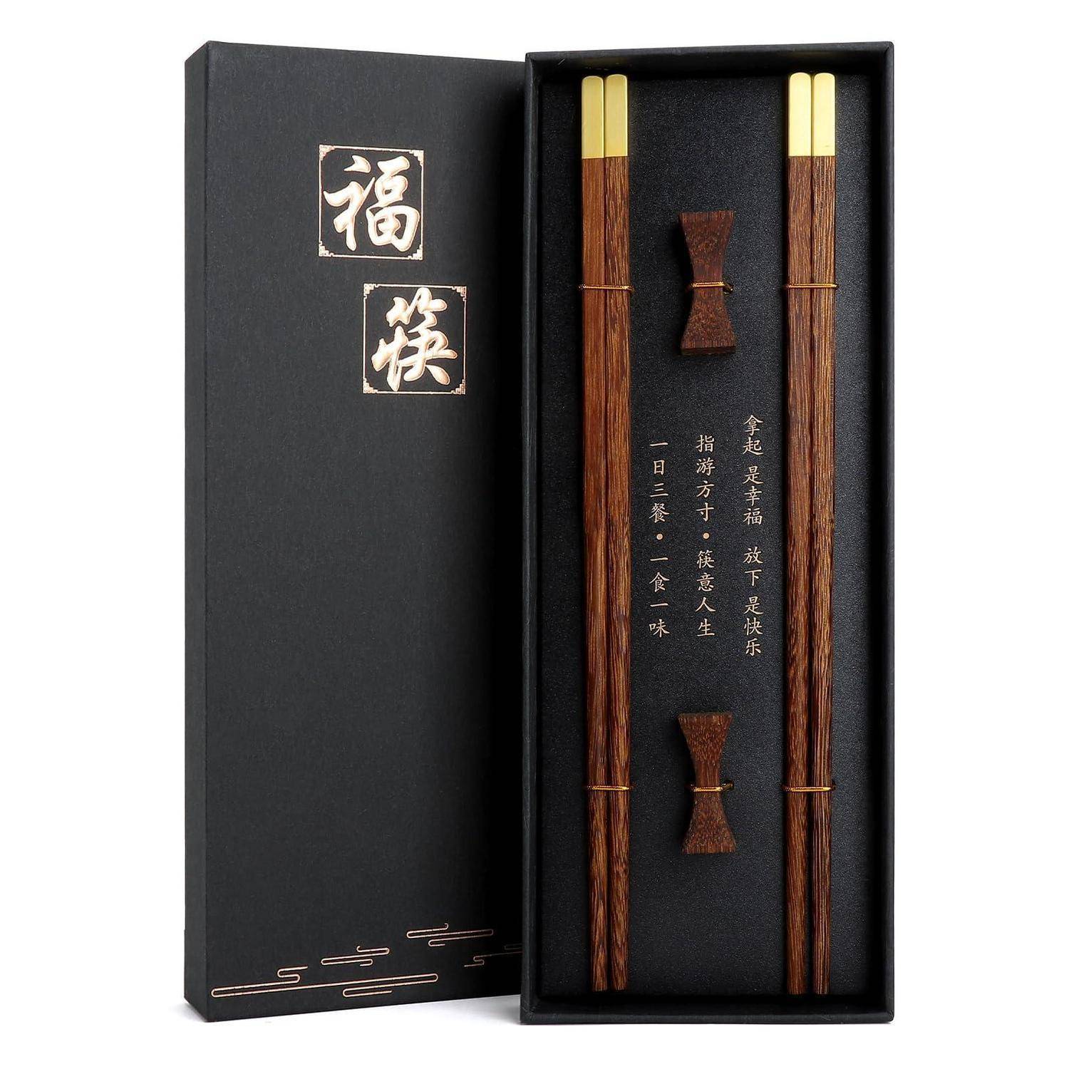 Schwarze Geschenkbox mit chinesischer Kalligraphie und einem Paar Holzstäbchen im Inneren, präsentiert in einem passenden Etui.