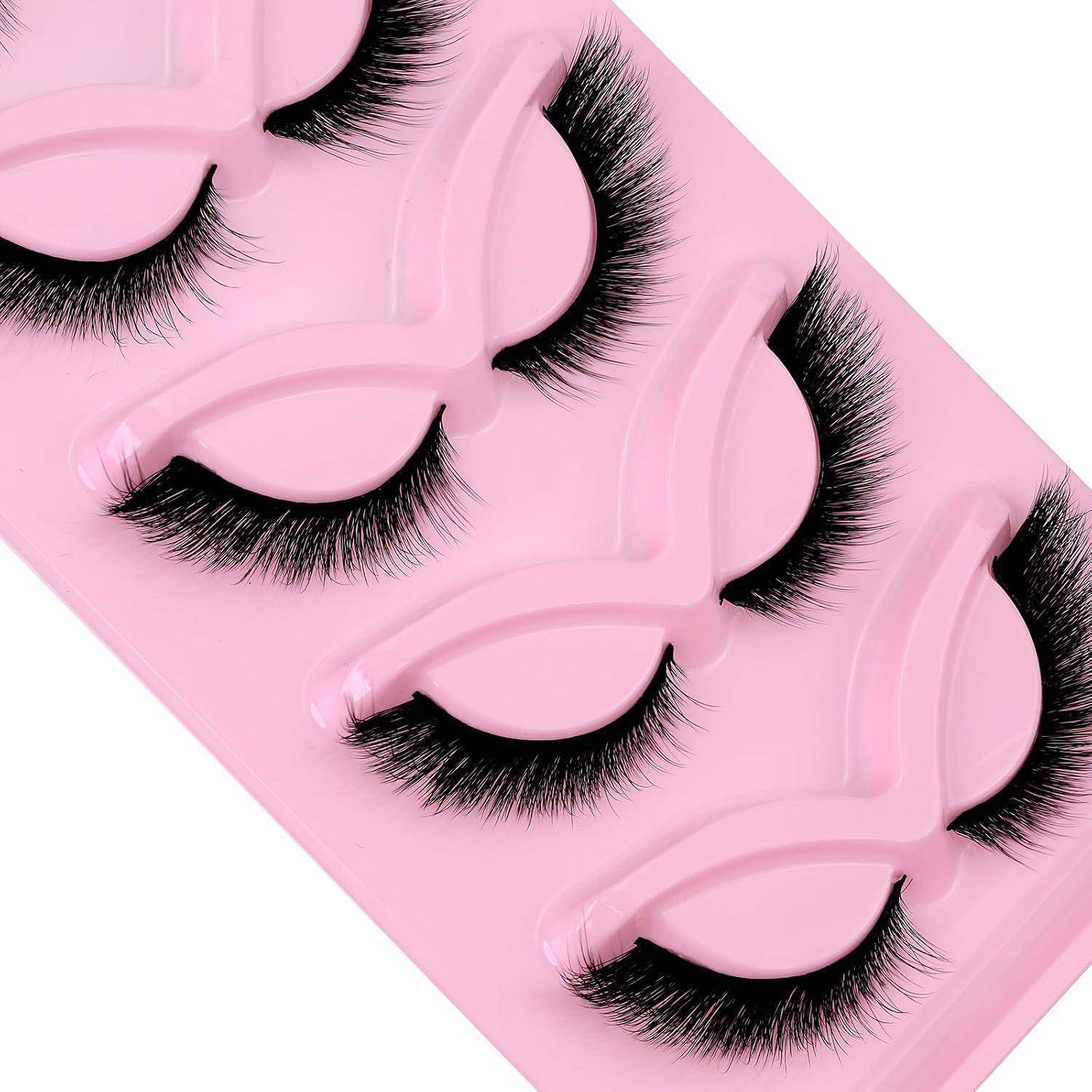 Streifen mit rosa falschen Wimpern mit mehreren Paaren langer schwarzer Wimpern auf weißem Hintergrund