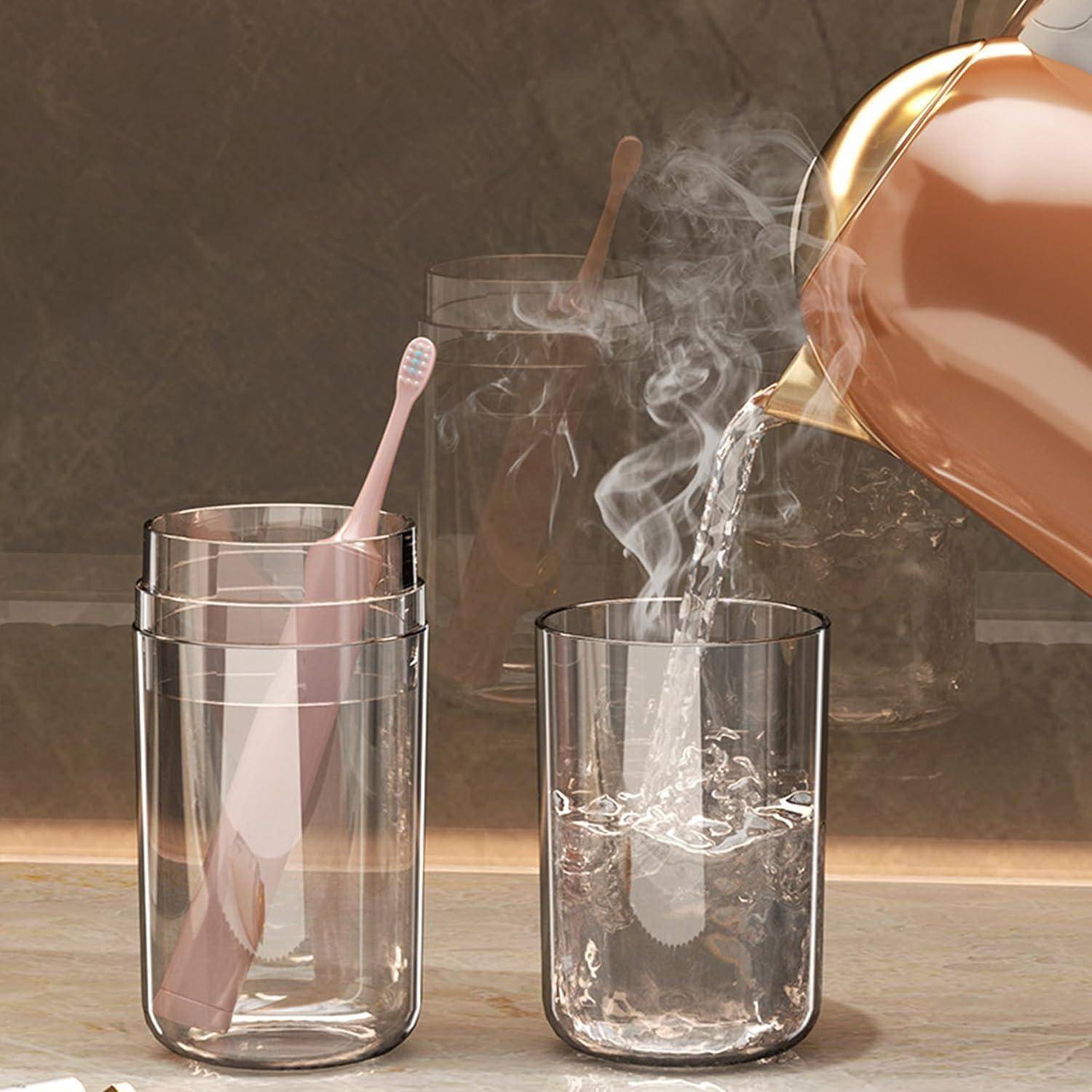 Kupferkessel gießt heißes Wasser in ein Glas, mit Dampf, der neben zwei klaren Gläsern aufsteigt, und einer rosa Zahnbürste in einem Glas.
