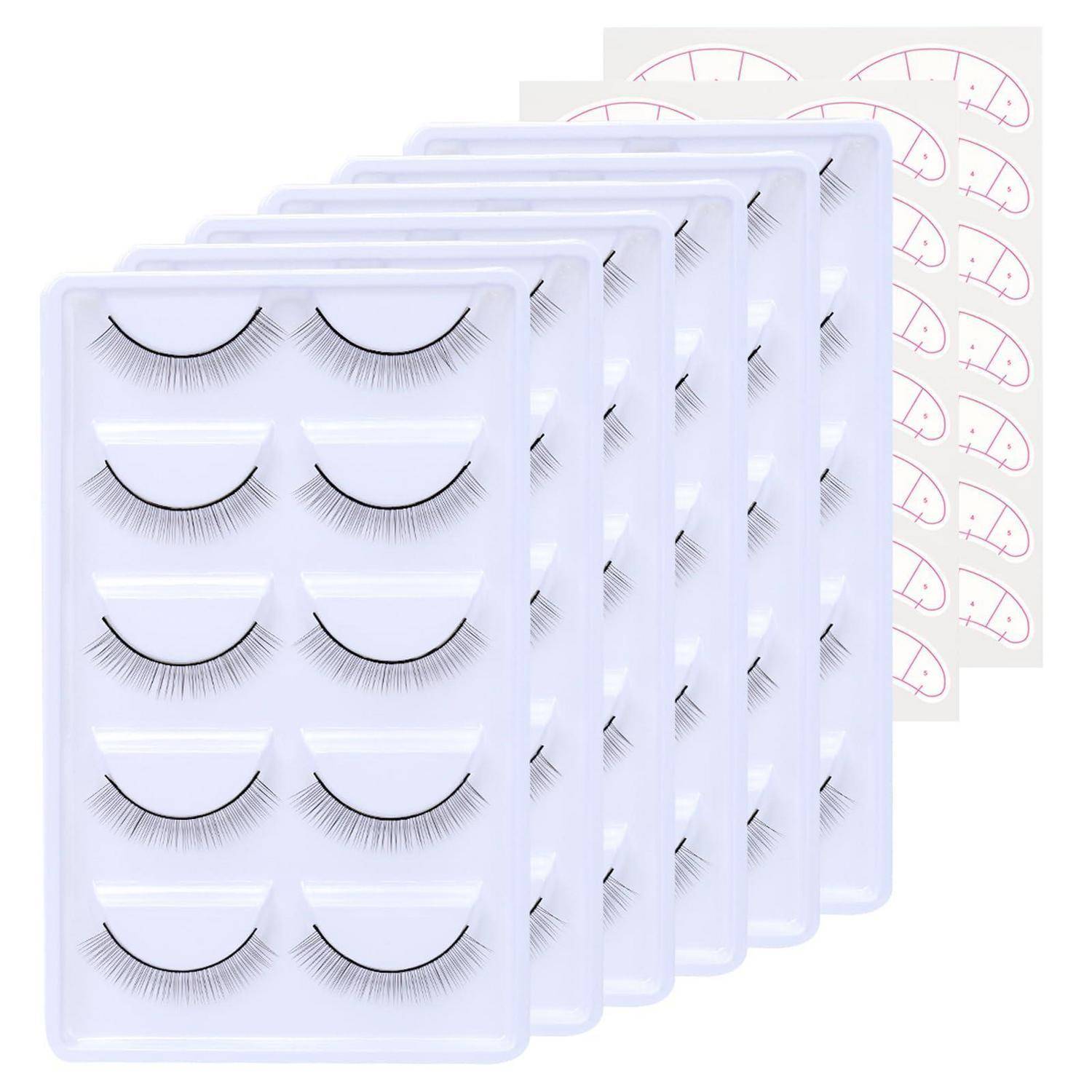 Stapel von Tablett mit künstlichen Wimpern, die mehrere Paar schwarzer Wimpern in durchsichtiger Kunststoffverpackung zeigen, mit gekrümmten Anwendungsanleitungsdiagrammen dahinter