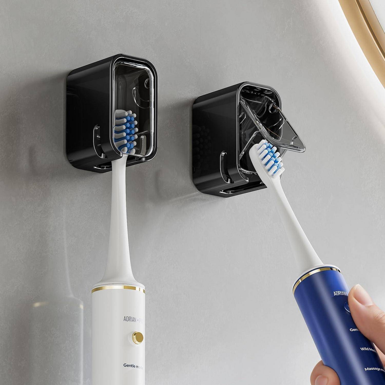Zwei elektrische Zahnbürsten in wandmontierten Ladeholtern, eine wird gerade in eine schwarze Dockingstation eingesetzt.