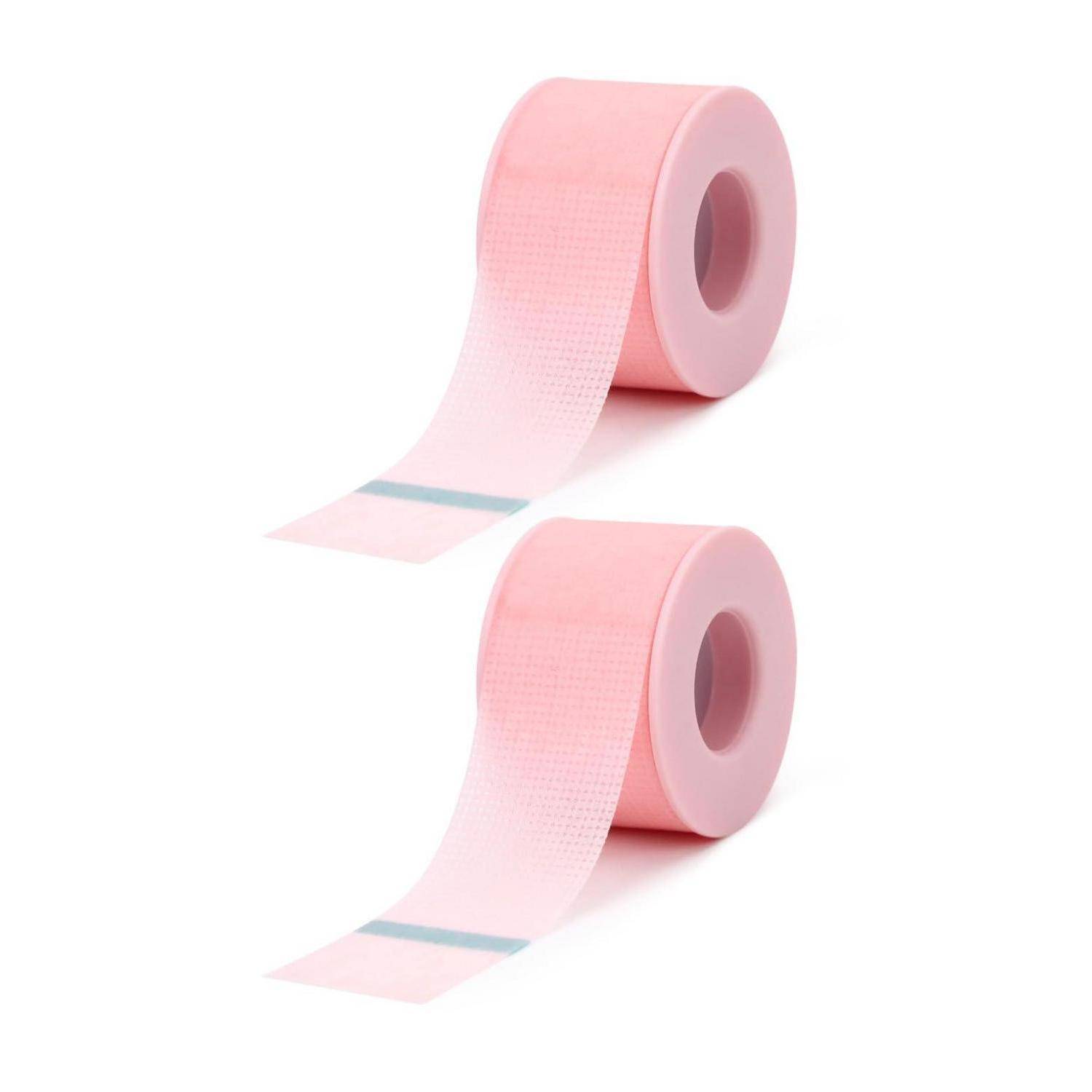 Zwei Rollen rosa Klebeband mit langen Streifen, die auf weißem Hintergrund abgerollt sind.