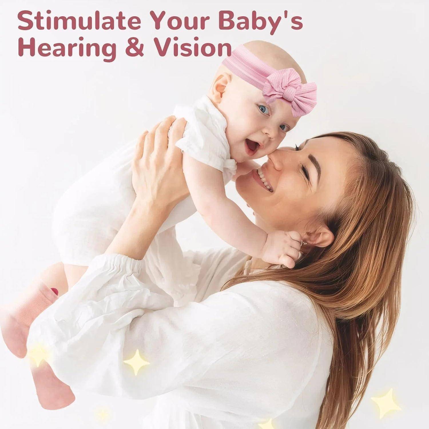 Lächelnde Mutter hält ein Baby mit einem rosa Stirnband hoch; Text sagt „Stimulieren Sie das Gehör und die Sehkraft Ihres Babys