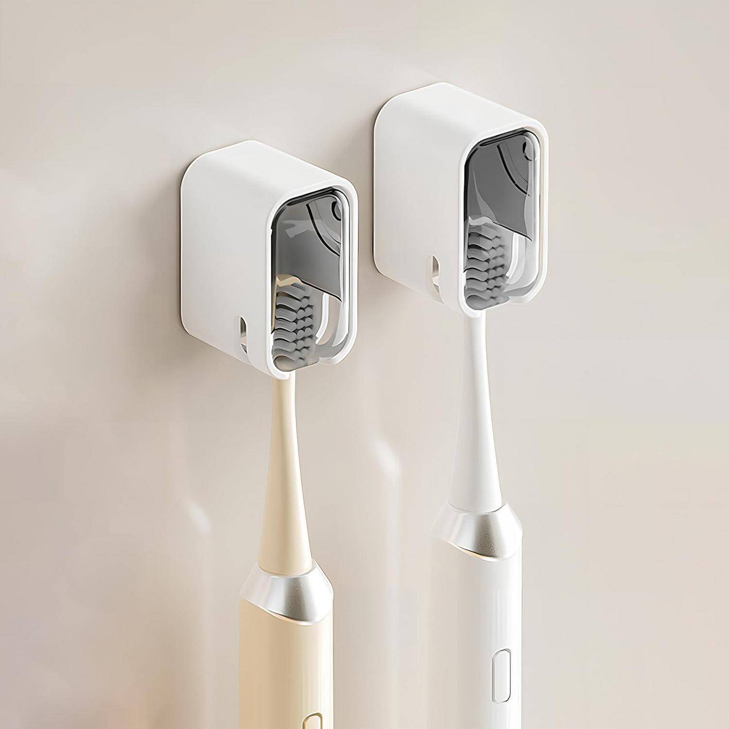 Zwei elektrische Zahnbürsten in wandmontierten Ladestationen, eine beige und eine weiße, vor einer schlichten hellen Wand dargestellt.