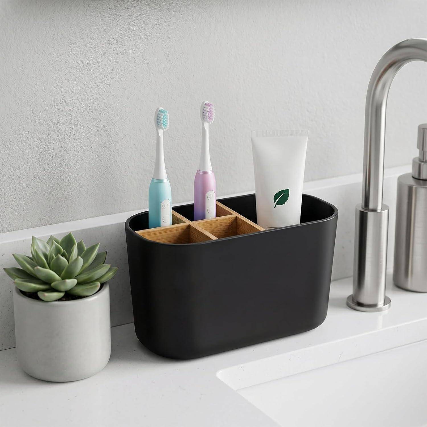 Badezimmer-Spülbecken-Caddy mit zwei Zahnbürsten, einer Tube und einem Bambus-Organizer neben einem Topf mit einer Sukkulente und einem Wasserhahn.