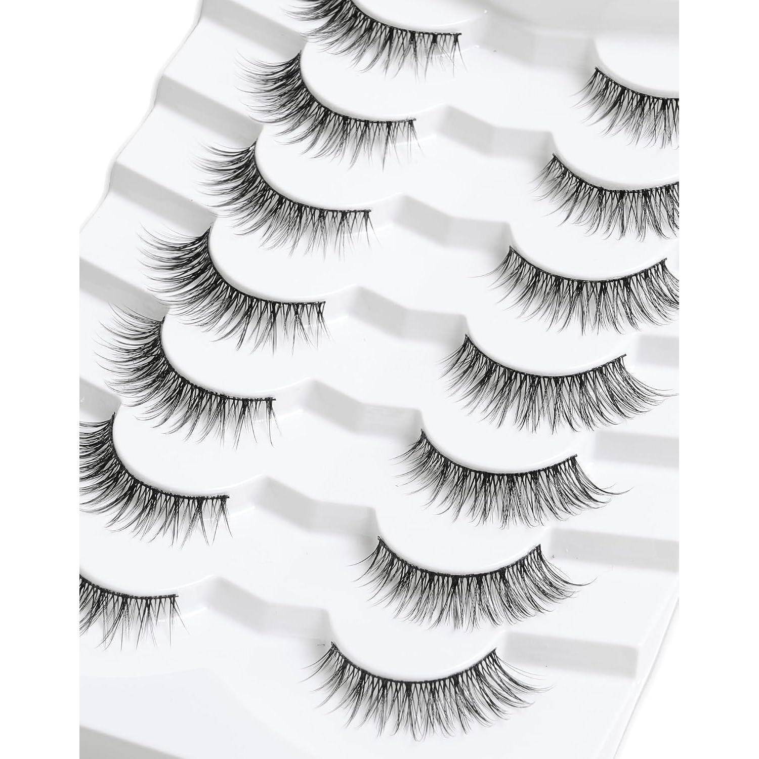 Mehrere Paare von künstlichen Wimpern, die in einem weißen Präsentationstablett angeordnet sind und verschiedene Längen und Stile zeigen.