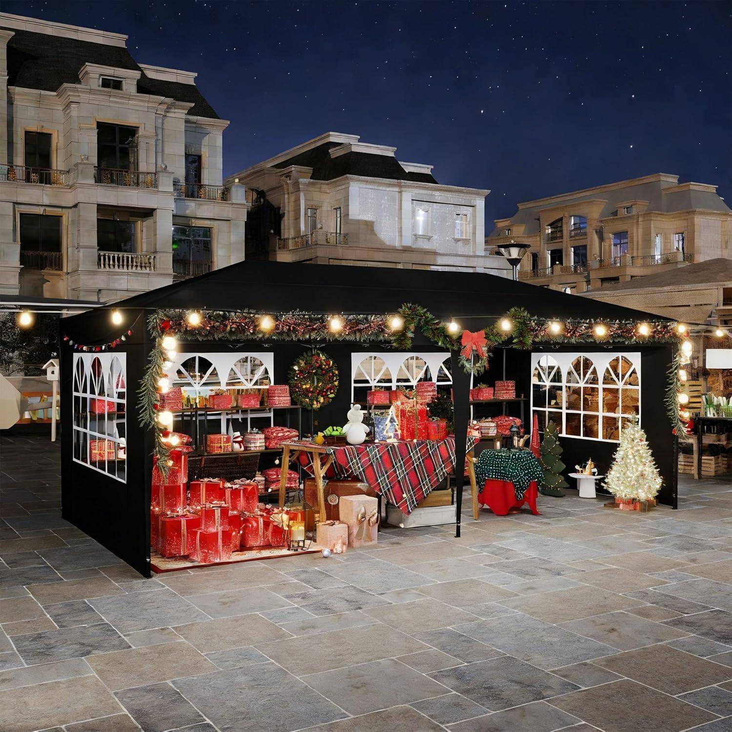 Festlicher Außenmarktstand, dekoriert mit Lichtern, Girlanden und roten Geschenken unter einem Nachthimmel auf einem Marktplatz in der Stadt.