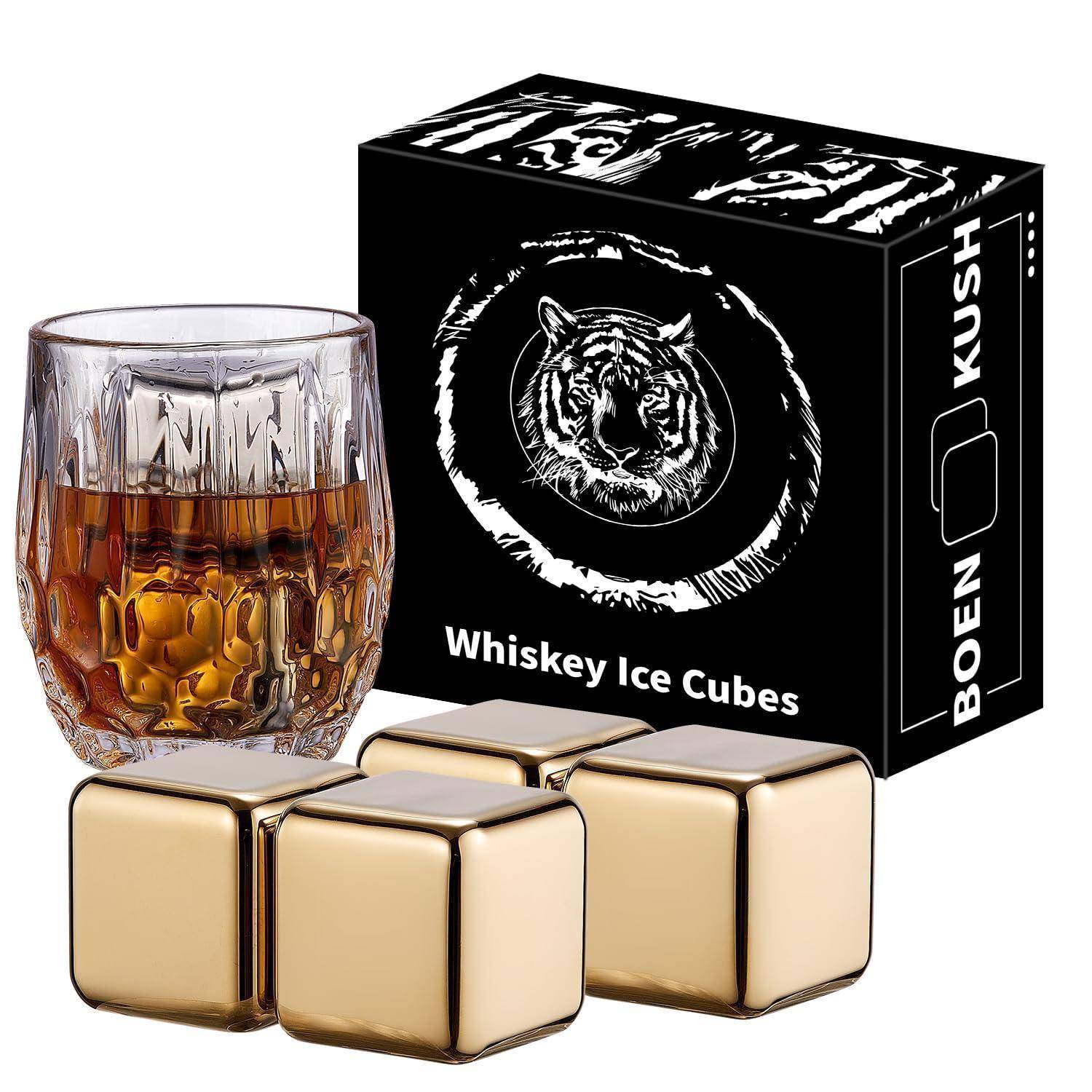 Produktfoto von Whiskey-Eiswürfeln: vier goldene würfelförmige wiederverwendbare Eissteine neben einem Whiskyglas und schwarzer „Whiskey Ice Cubes