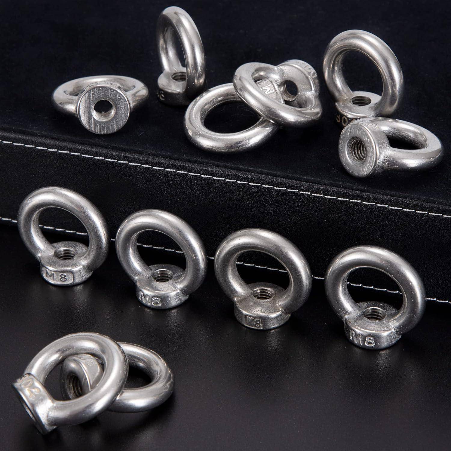 Metallische Hebel-Augenmuttern mit Gewindelöchern, dargestellt aus verschiedenen Winkeln auf einer schwarzen Oberfläche.