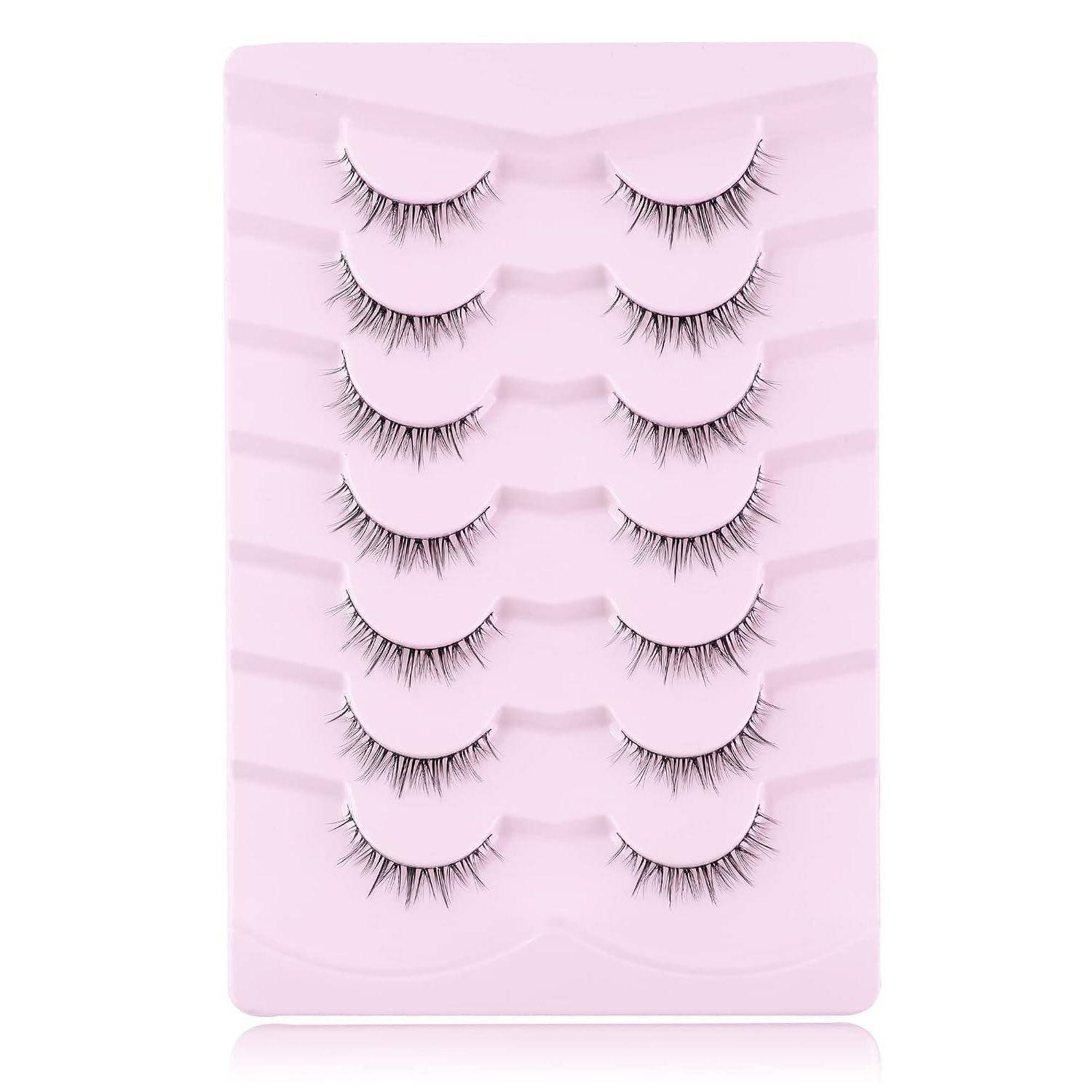 Packung mit falschen Wimpern auf einer rosa Displaykarte angeordnet, zeigt mehrere Paare von feinen schwarzen Wimpern.