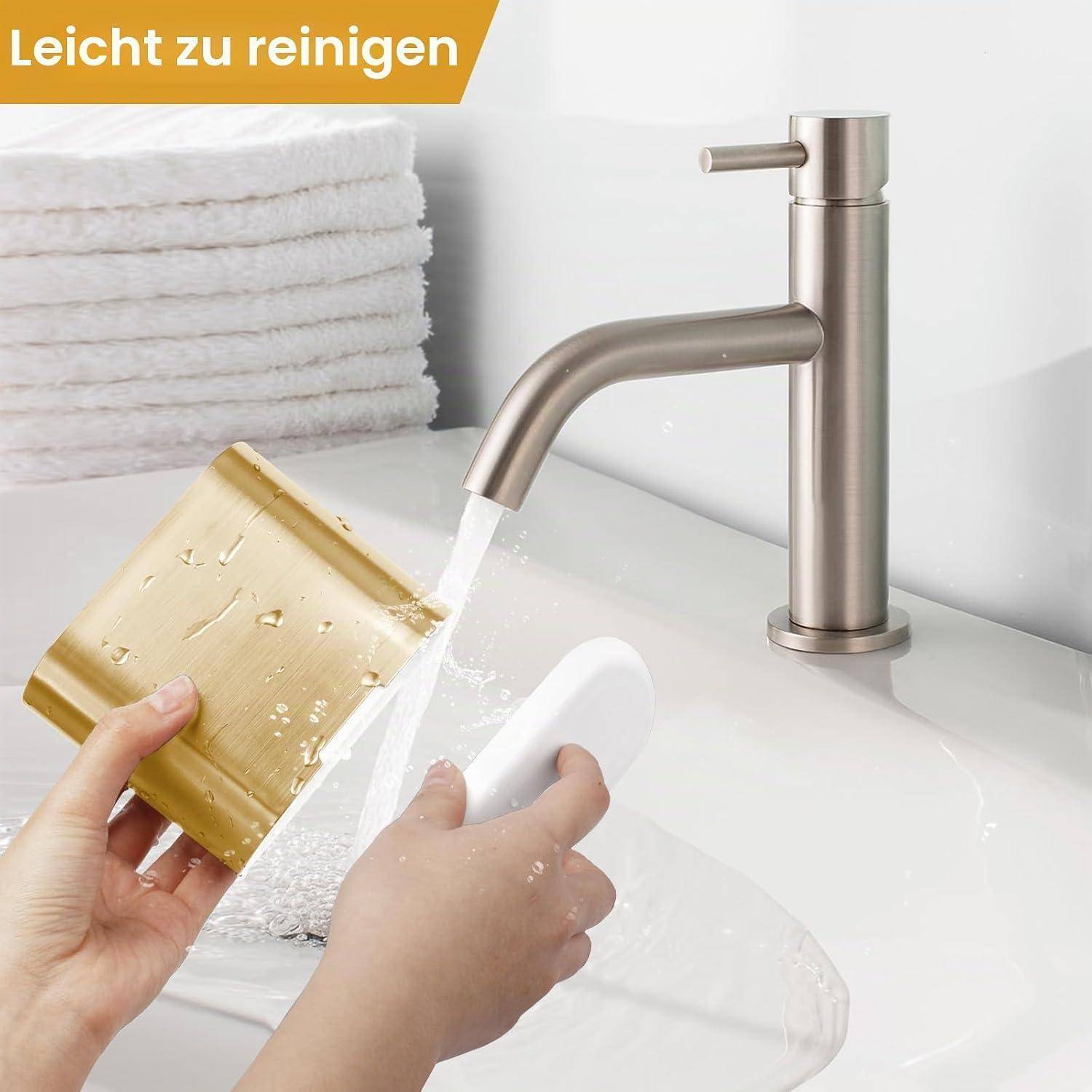 Hände spülen einen goldfarbenen und weißen Badezimmer-Abzieher unter einem Wasserhahn; Text sagt „Leicht zu reinigen