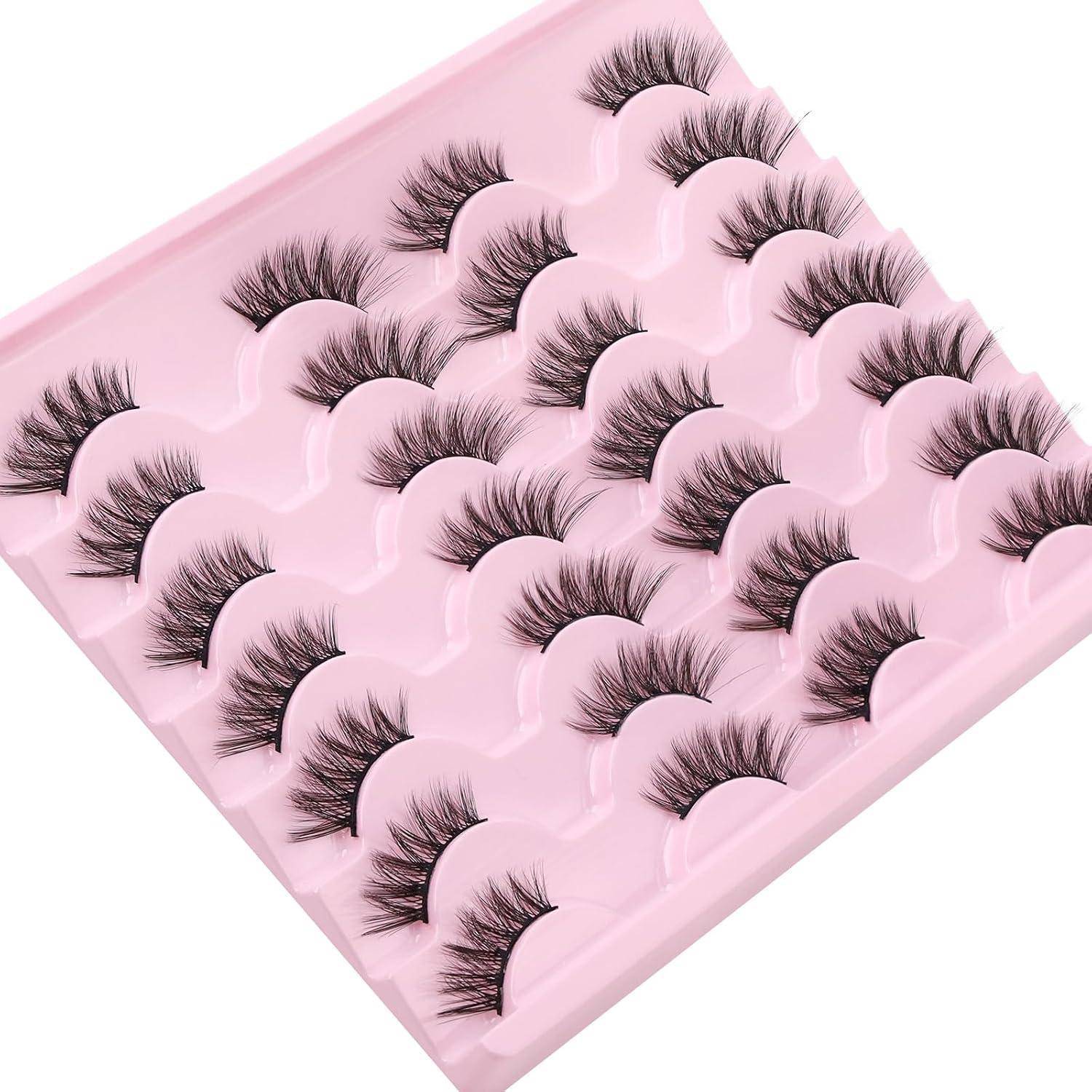 Rosa Tablett mit mehreren Paaren von künstlichen Wimpern, die in Reihen angeordnet sind