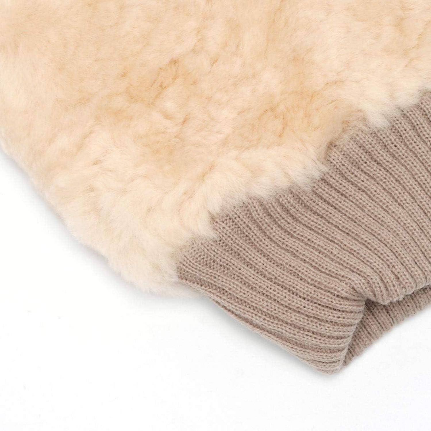Nahaufnahme einer beigen, pelzgefütterten Strickhose an weißem Hintergrund.