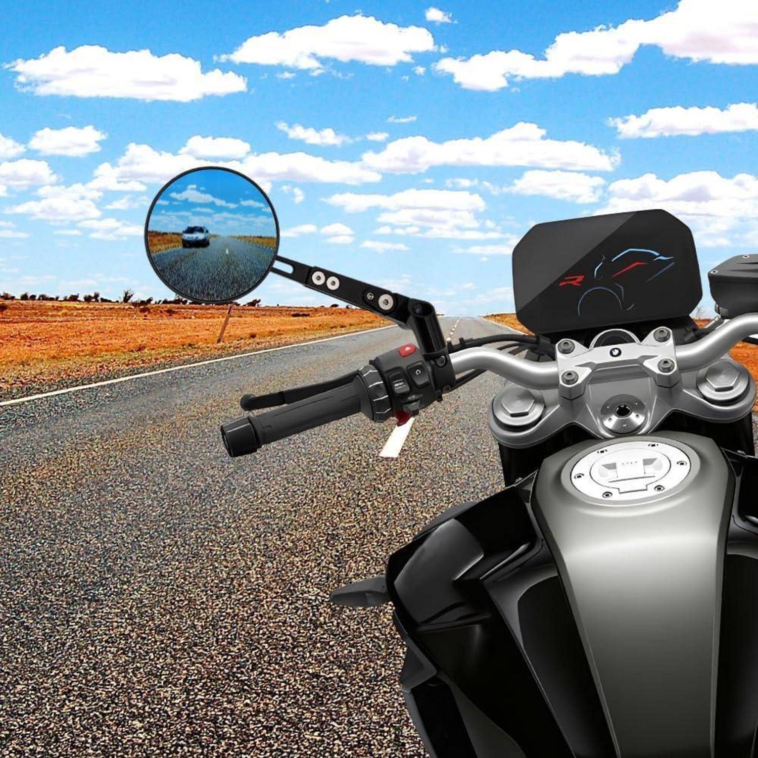 Ansicht eines Motorradfahrers auf einer Autobahn, die den Lenker, den Spiegel mit einem Auto dahinter und die offene Straße unter einem blauen Himmel zeigt.