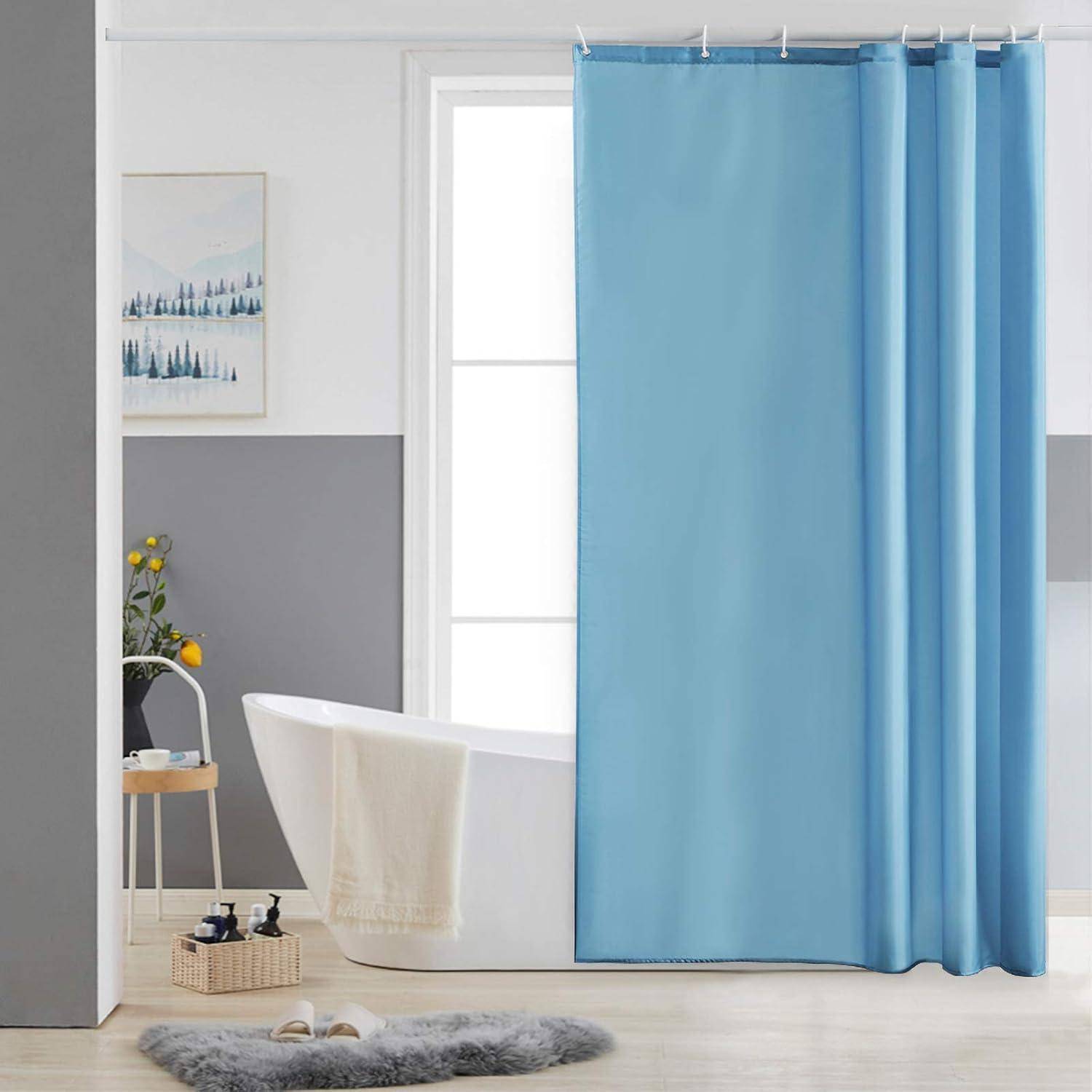 Hellblauer Duschvorhang neben einer weißen freistehenden Badewanne in einem minimalistischen Badezimmer.