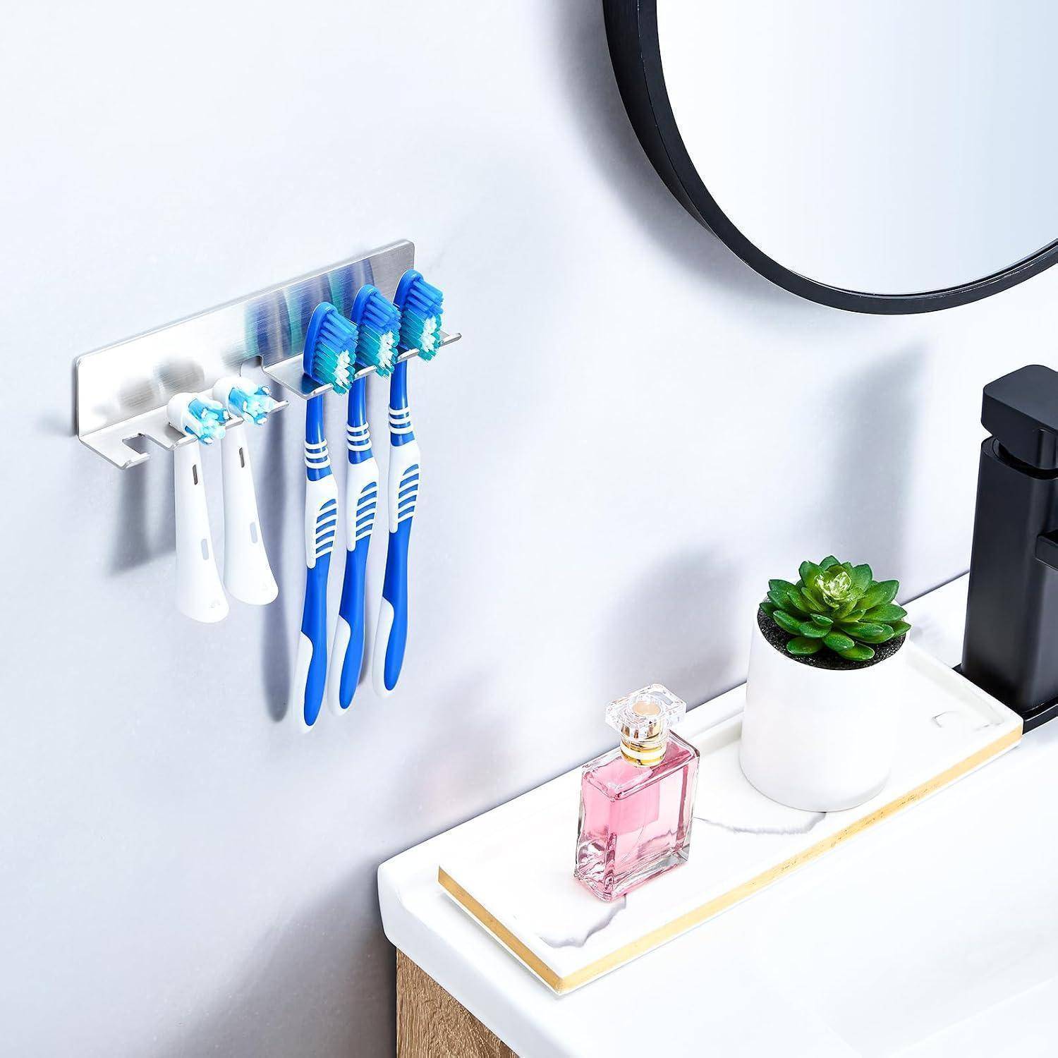 Badezimmerregal an der Wand mit Zahnbürsten und Rasierapparaten über einer Spülentheke mit Spiegel, Parfümflasche und kleinem Sukkulenten-Topf.
