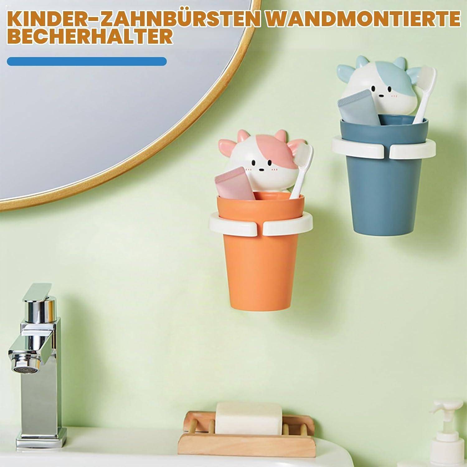 An der Wand montierte Zahnbürstenhalter für Kinder in Katzenform mit orangefarbenen und blauen Bechern, angezeigt in einer Badezimmerszene.