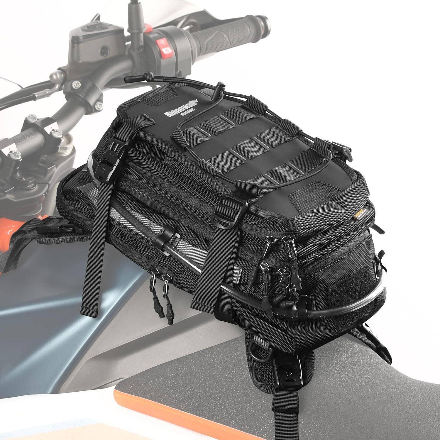 Schwarze Motorradtankrucksack, befestigt am Benzintank und Lenker, mit mehreren Reißverschlusstaschen und Spanngurt oben.