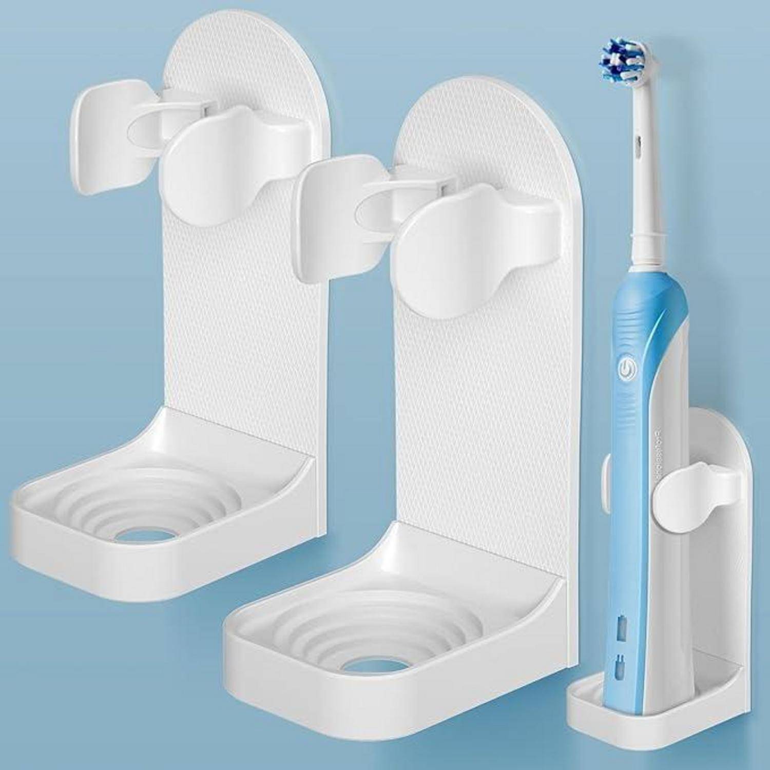 Weiße wandmontierte Behälter mit Saugnapfrücken für eine elektrische Zahnbürste, gezeigt mit einer blauen Zahnbürste in einer Badezimmer-Stil-Produktpräsentation.