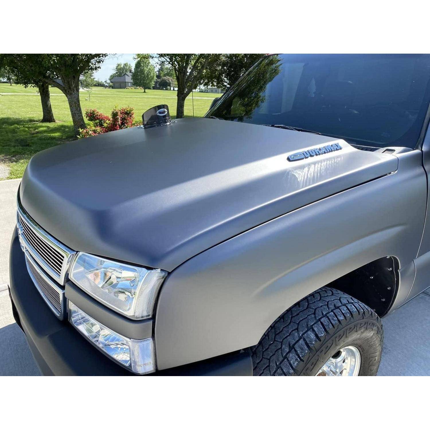 Nahaufnahme der mattschwarzen Motorhaube und der vorderen Fahrerseite eines Pickup-Trucks, der im Freien in der Sonne geparkt ist.