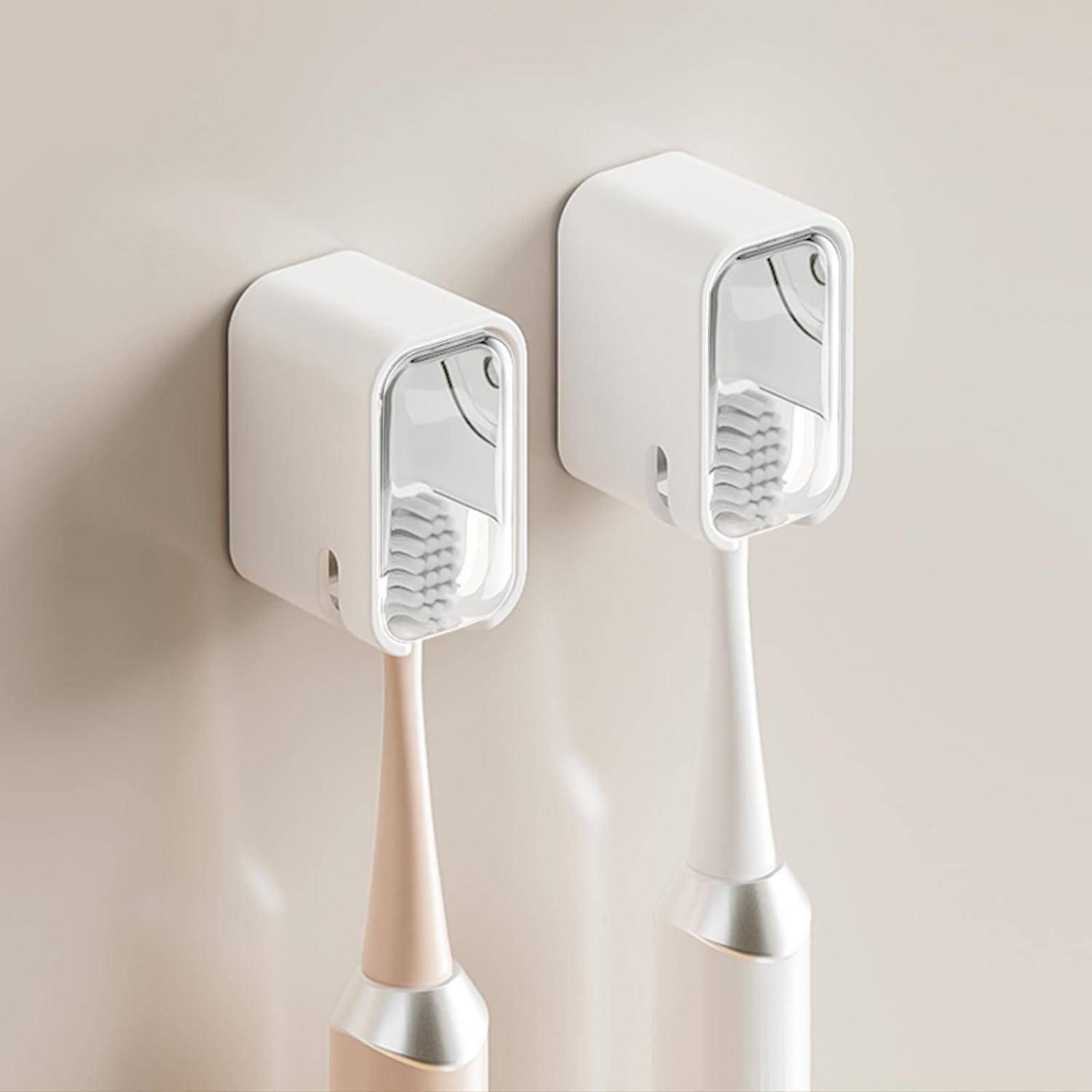 Zwei an der Wand montierte Behälter für elektrische Zahnbürsten mit vertikal hängenden Zahnbürsten vor einer beigen Wand.
