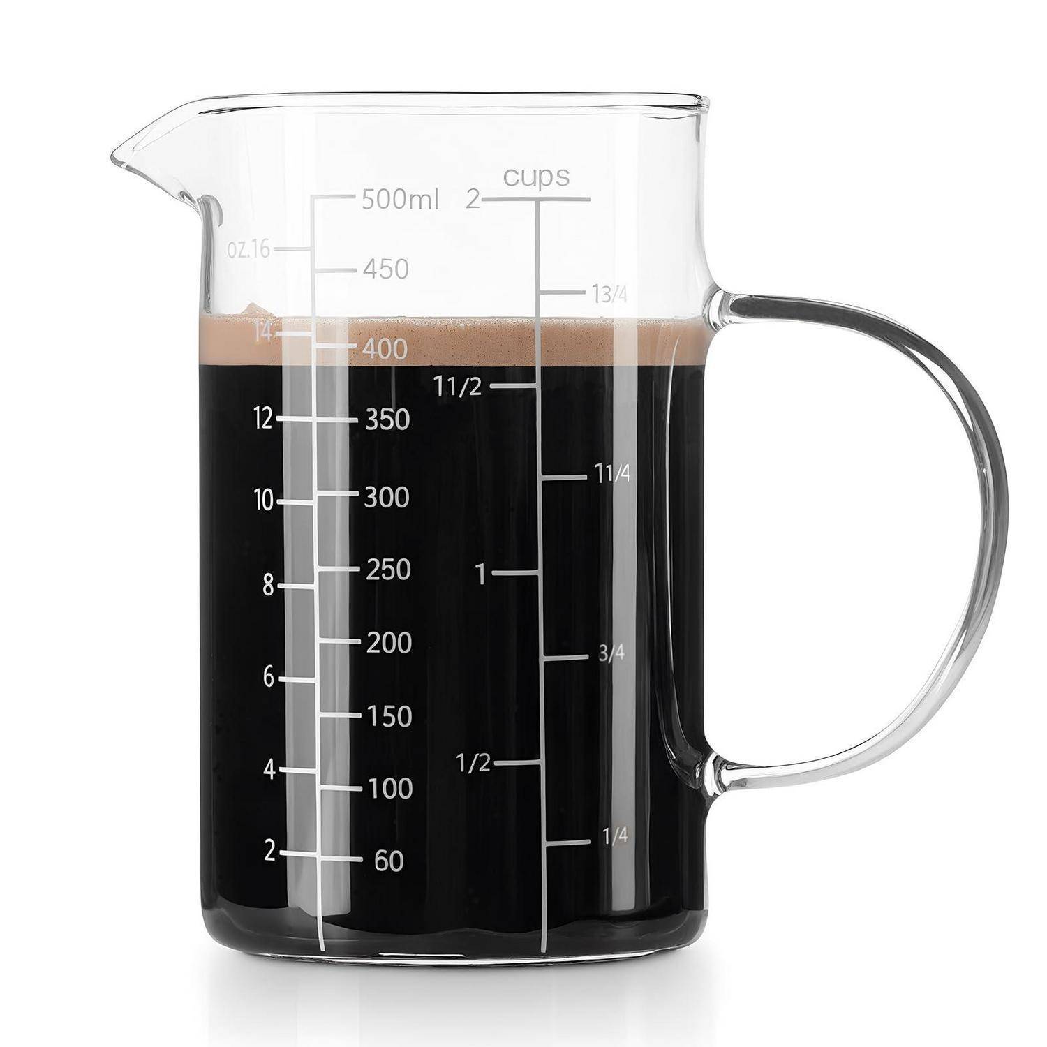 Glaskaffee-Messbechergefüllt mit dunklem Kaffee, gekennzeichnet mit Milliliter- und Tassenmessungen.